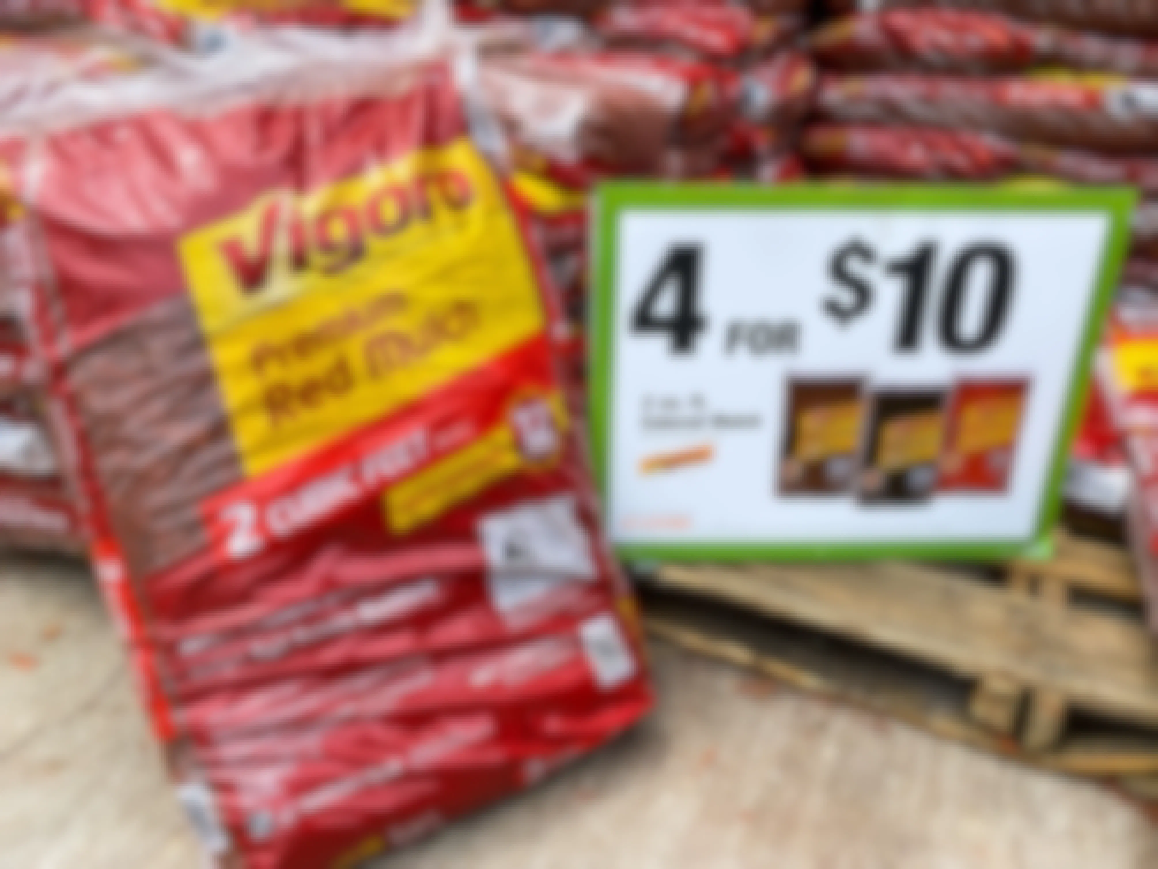  A bag of vigoro red mulch next to a 4 for $10 sign at Home Depot