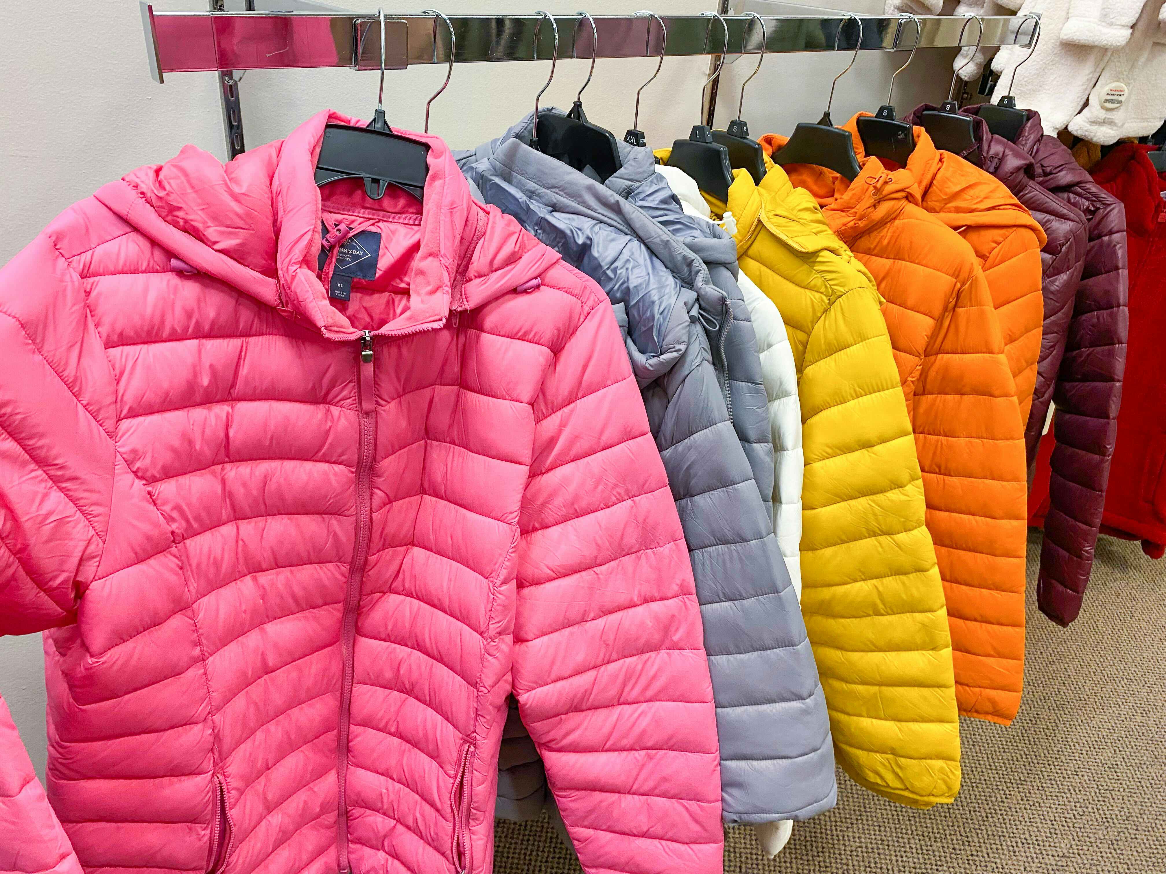 Puffer coats in different colors hanging on a clothing rack at JCPenney