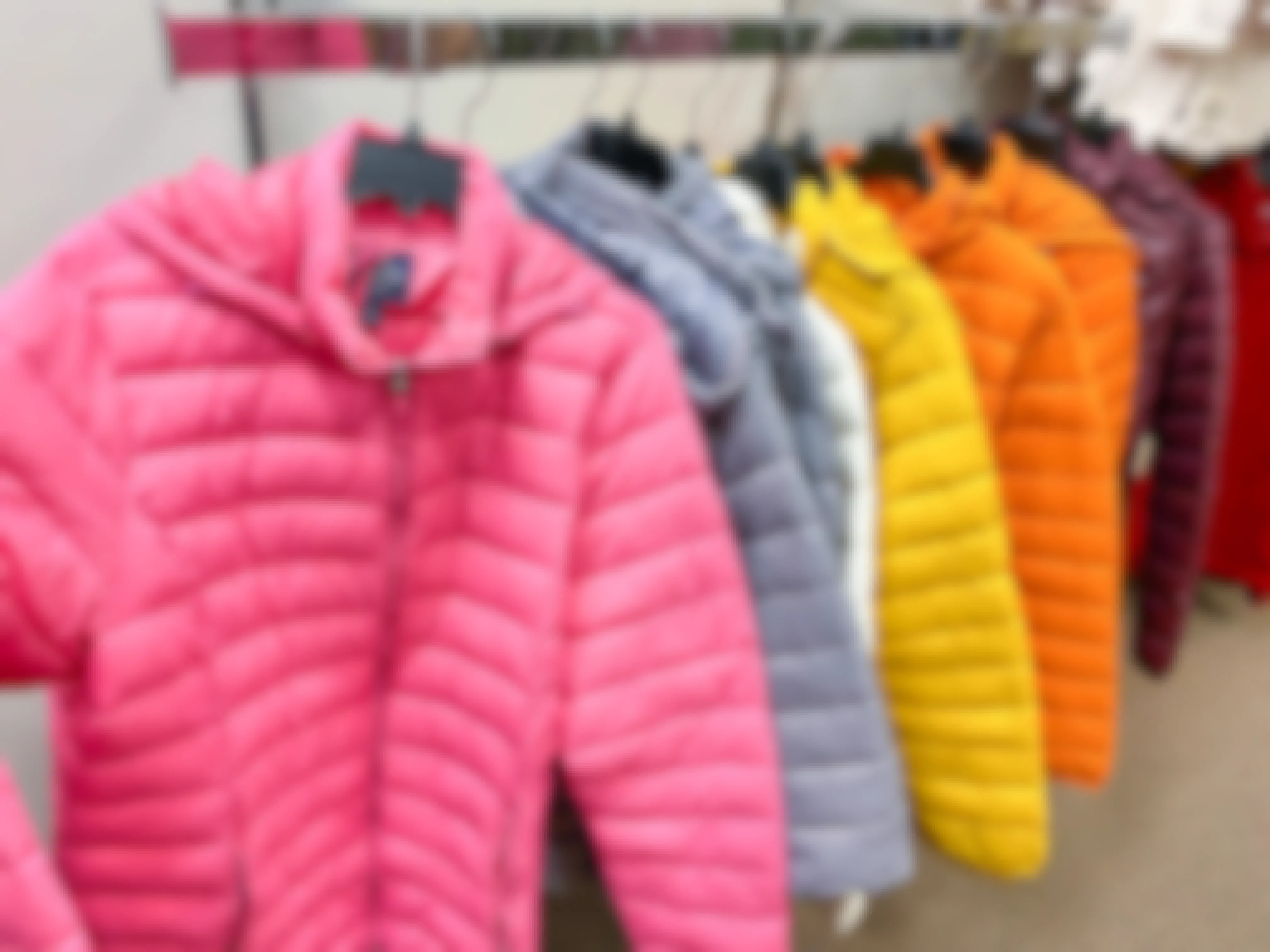 Puffer coats in different colors hanging on a clothing rack at JCPenney