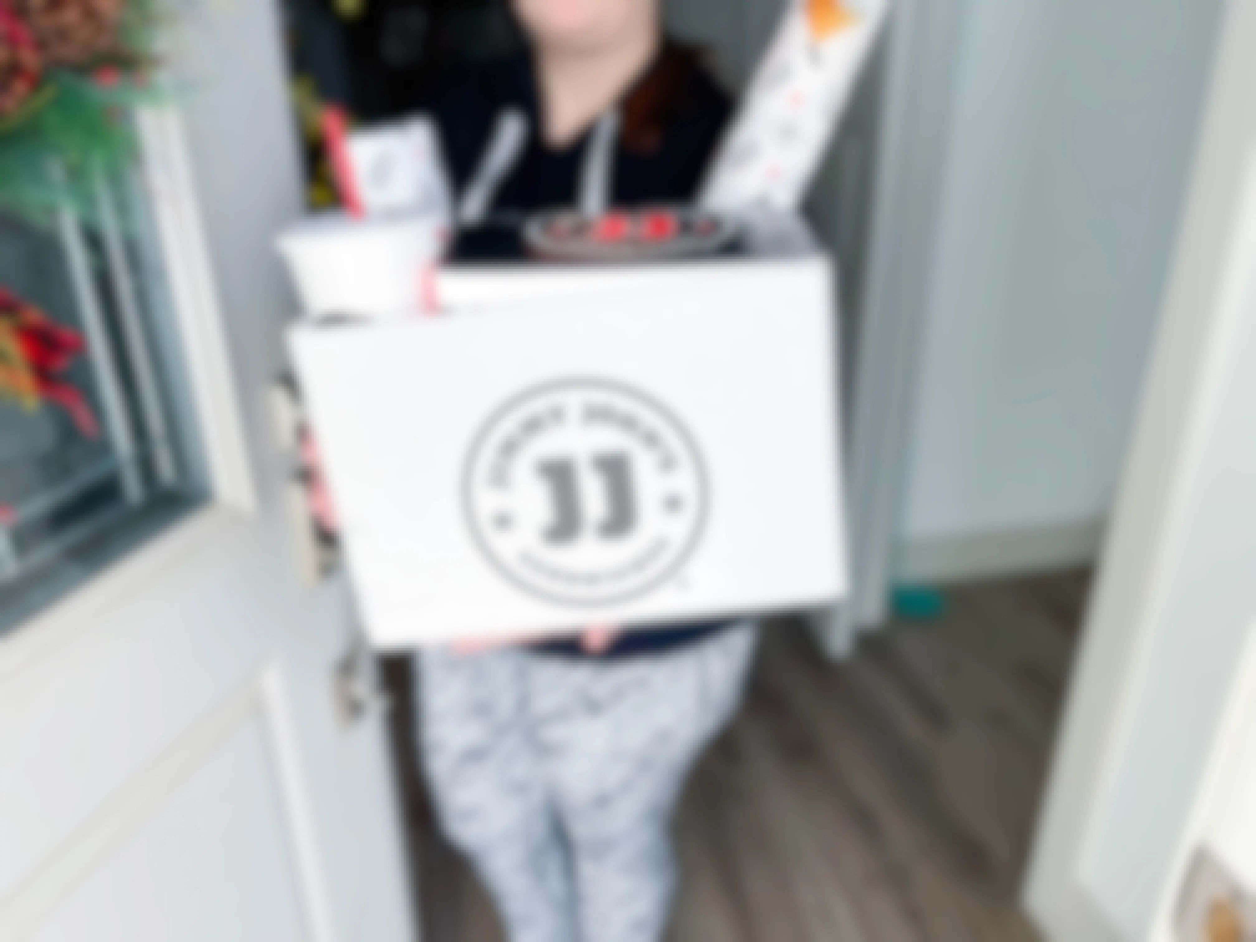 woman holding box of jimmy johns delivery 