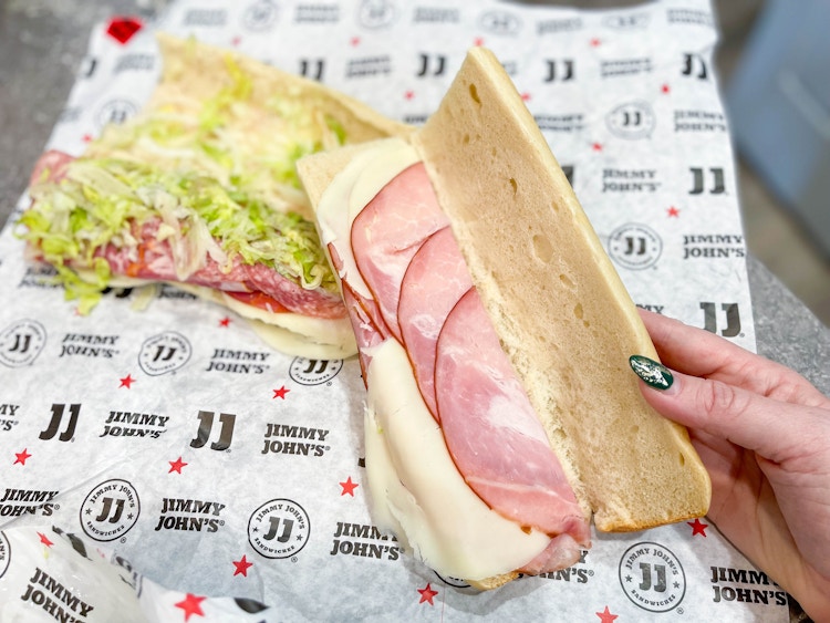 hand opening up jimmy johns leave in bread sandwich 