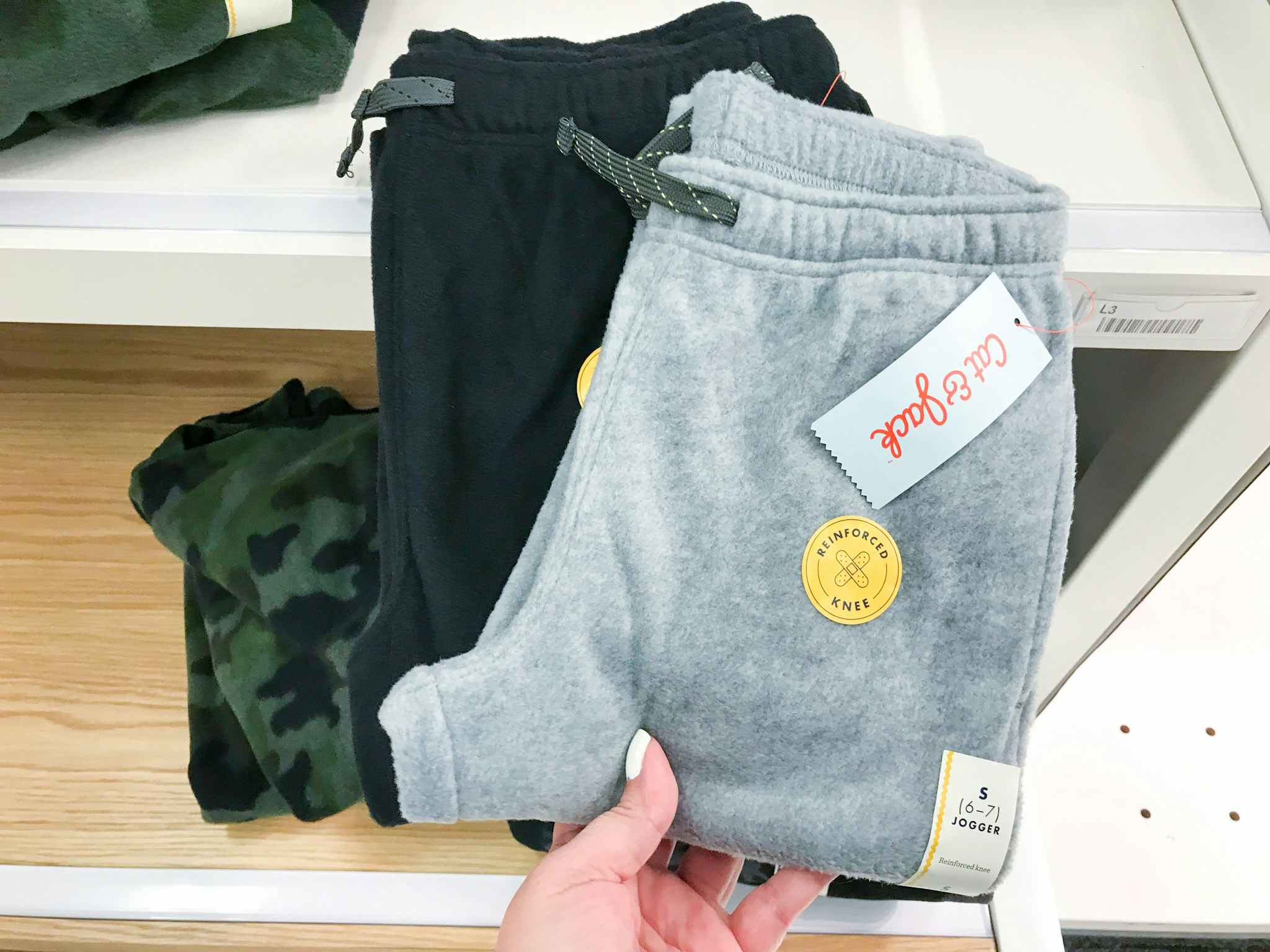 hand grabbing cay & jack kids fleece joggers off a target shelf