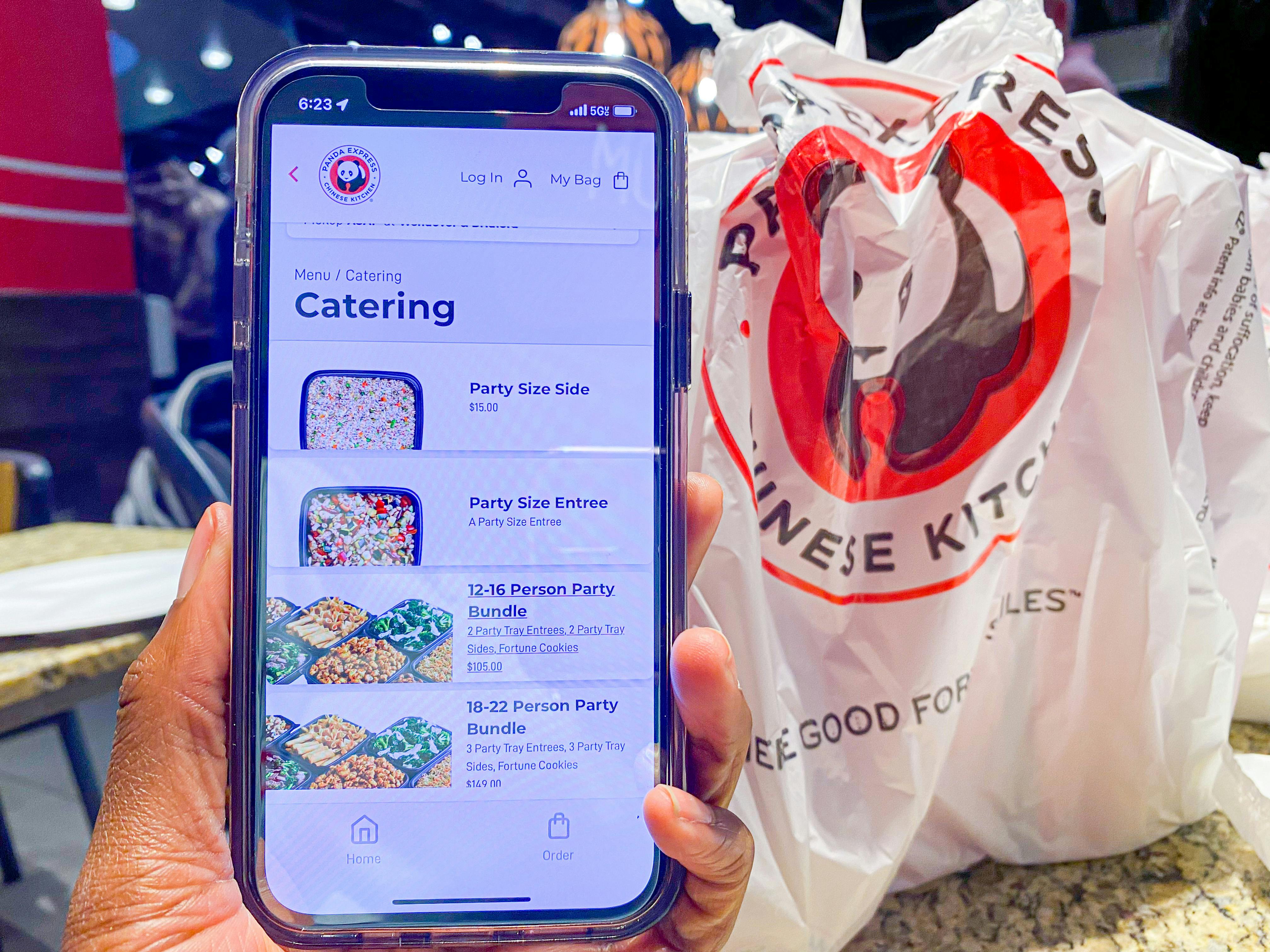 a phone held next to a bag of Panda Express