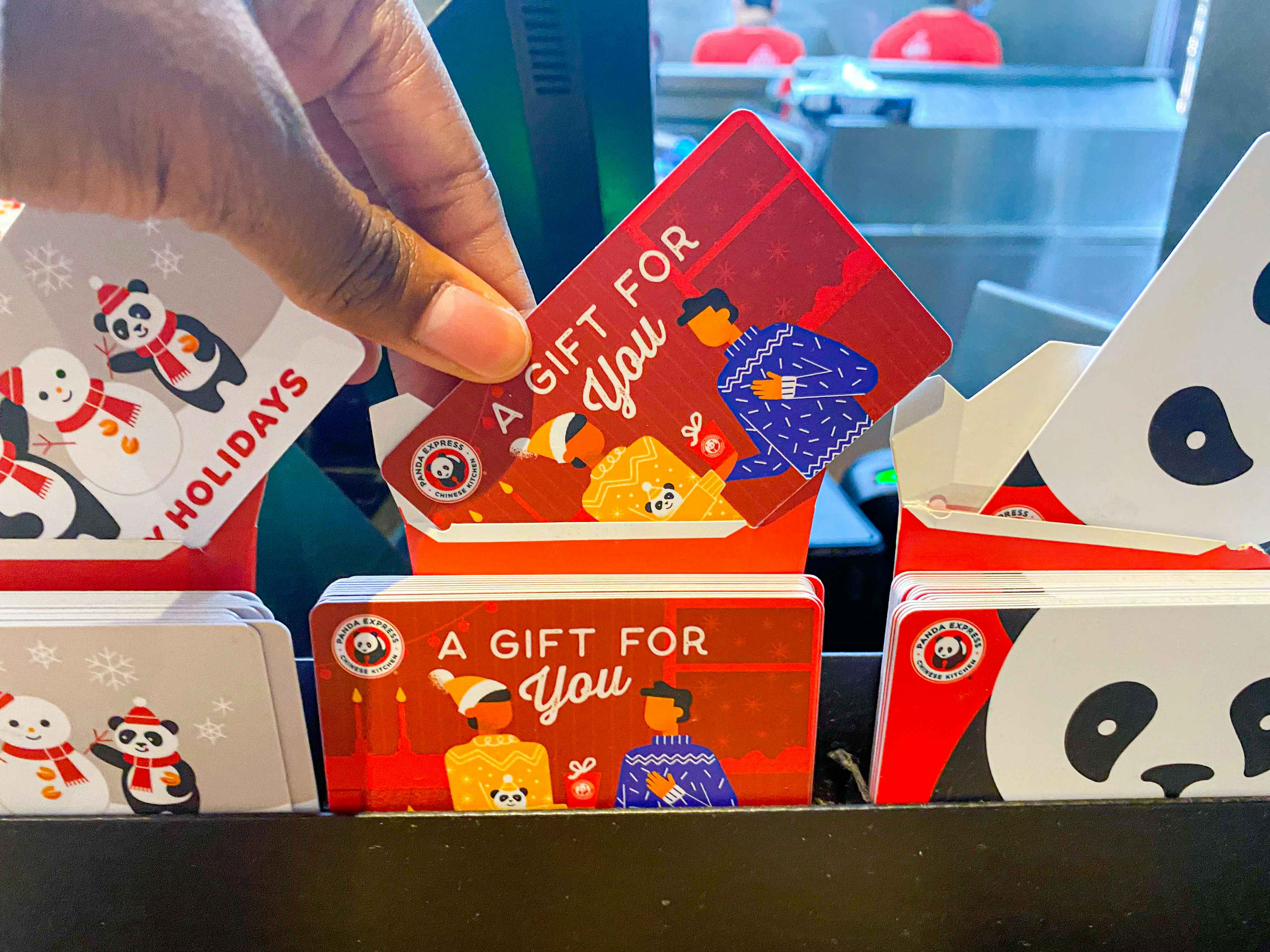 a gift card being picked up from an assortment of gift cards in Panda Express 