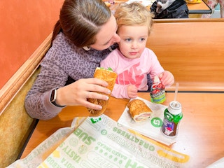 mom and daughter eating subway
