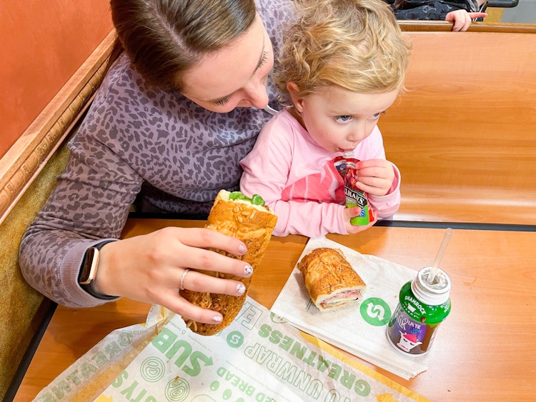 mom and daughter eating subway