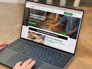 woman on laptop looking subway catering website