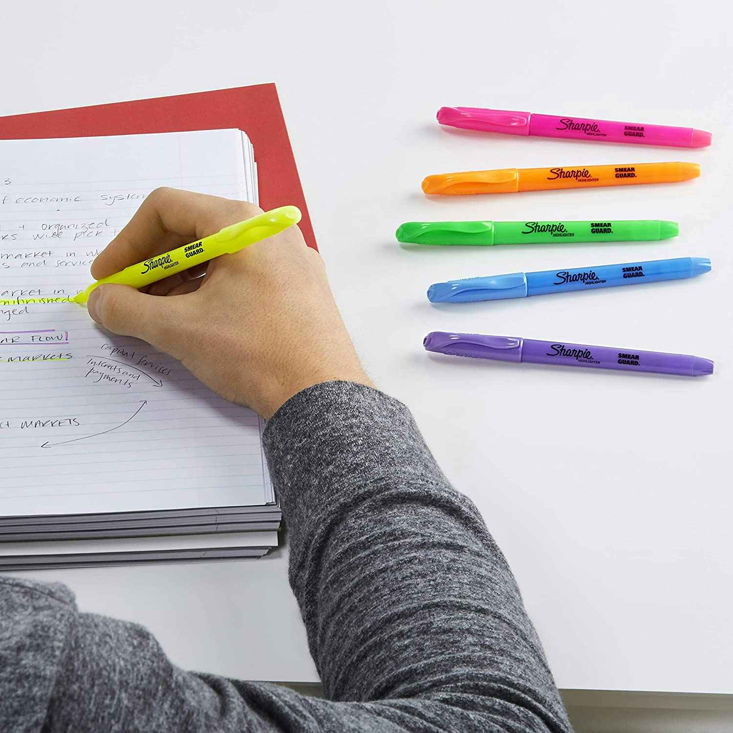 Someone using a highlighter to highlight notes.