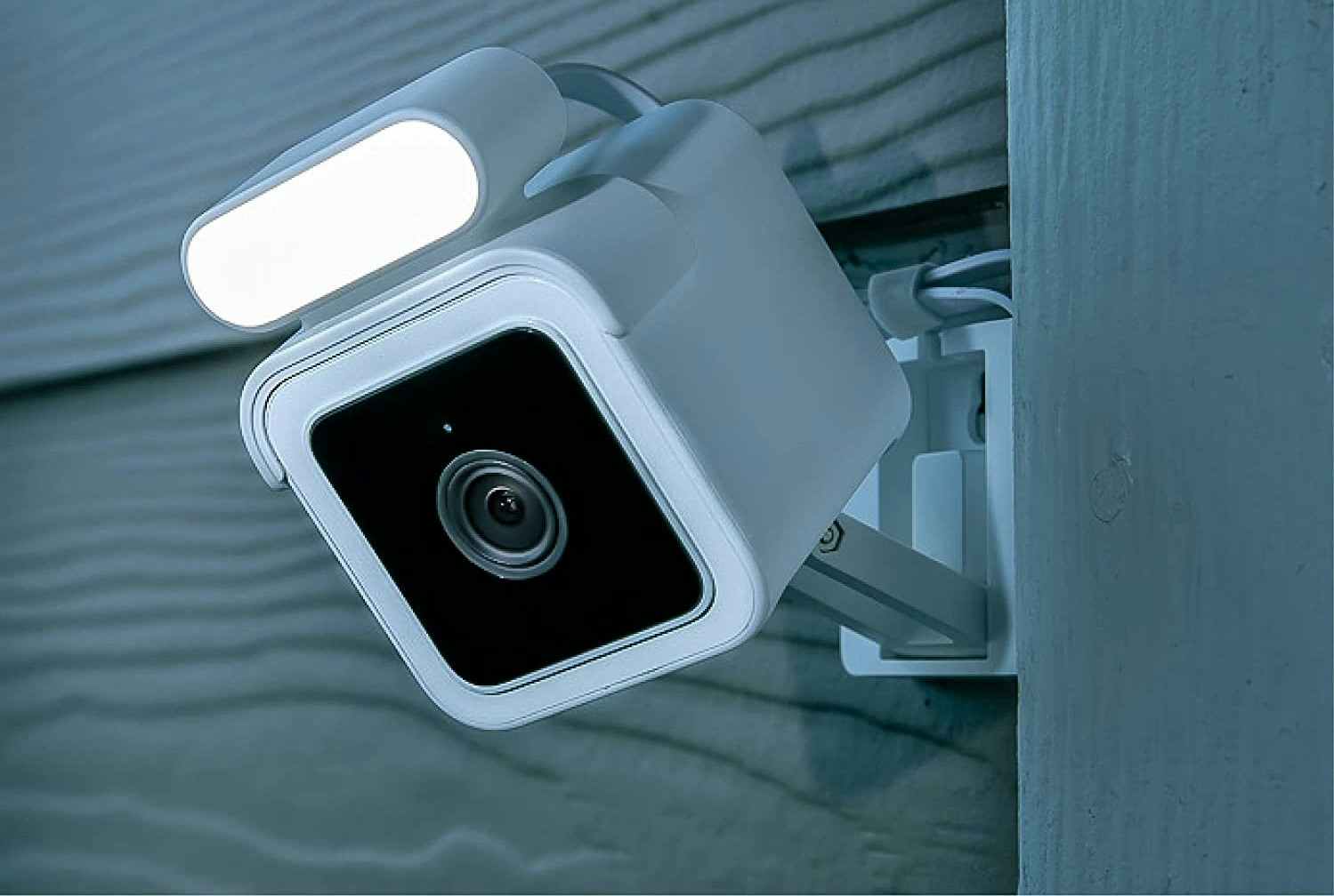 A Wyze spotlight security camera attached to a home.