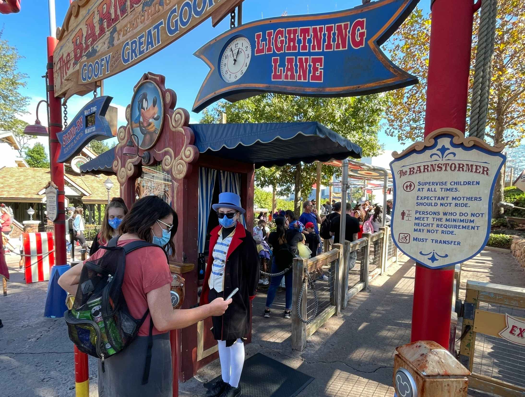 A person checking into Lightning Lane at the Barnstormer ride at Disney World.