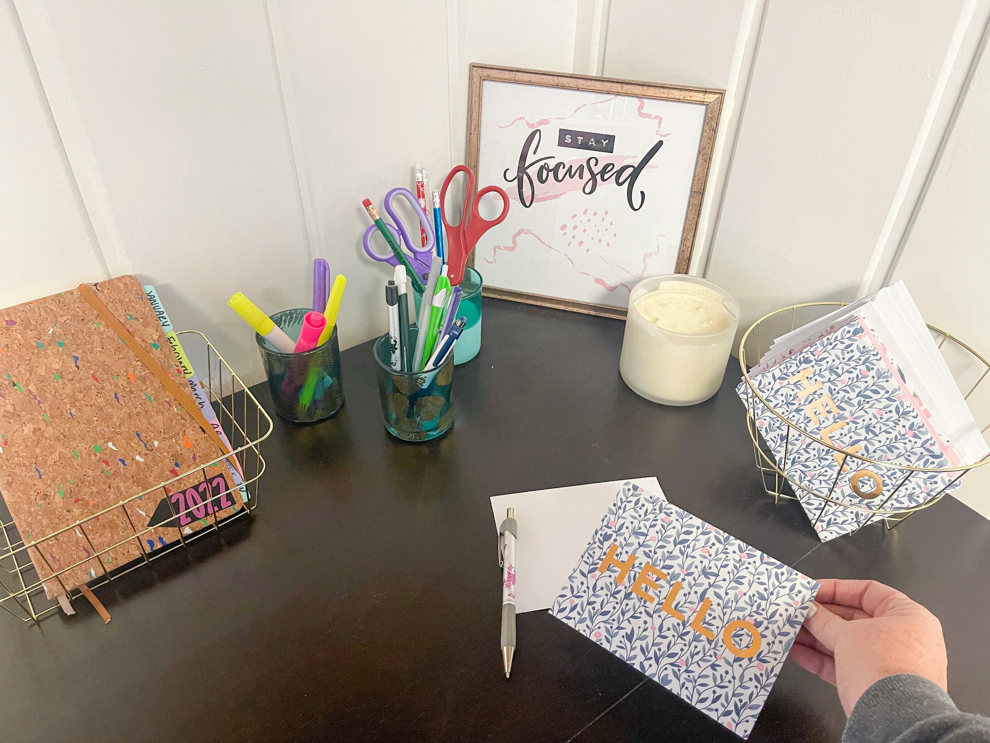 someone putting card on desk with organized baskets