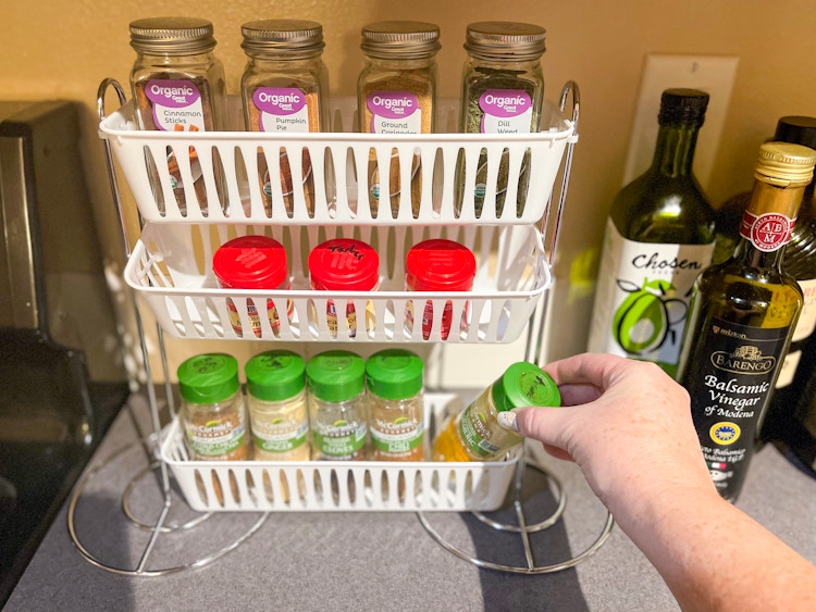 someone putting spice in basket and paper towel holder spice rack 