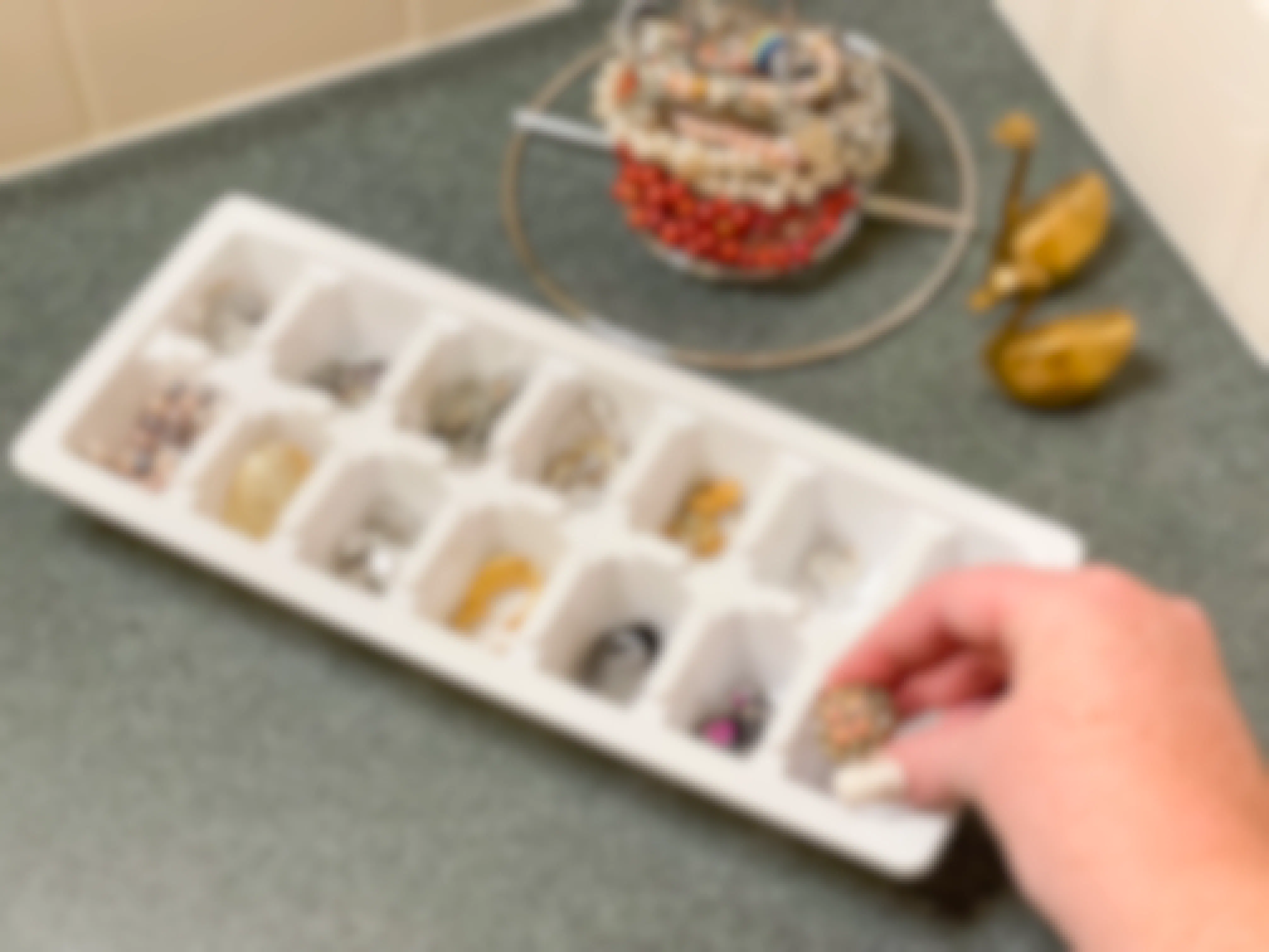 someone sorting jewelry into an ice tray