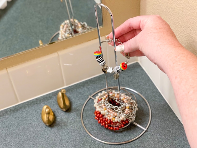 someone putting bracelets on paper towel holder