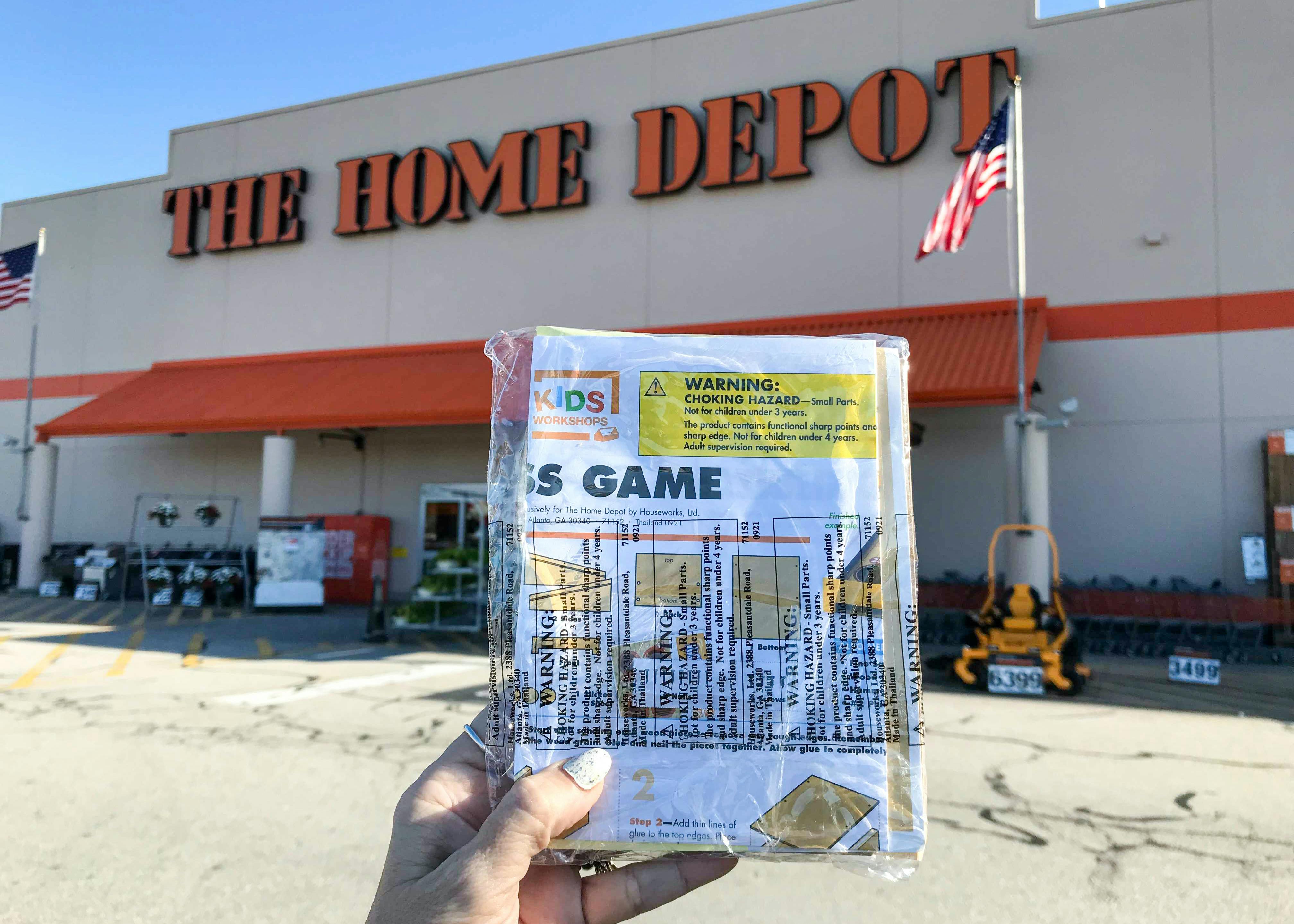 Someone holding a home depot kids free workshop toss game kit outside of a home depot store