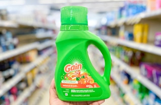 hand holding bottle of Gain in aisle