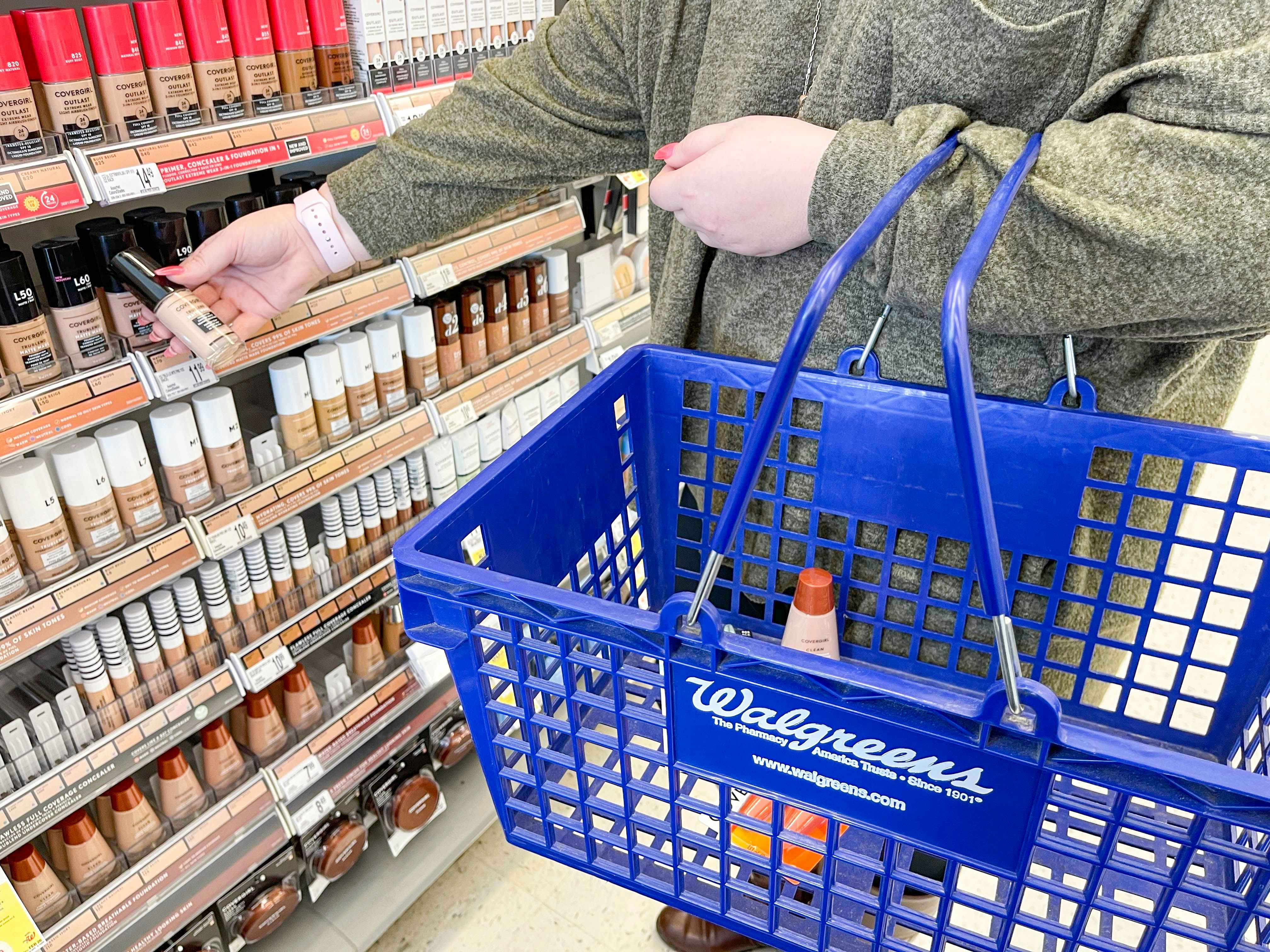 Someone shopping for makeup and putting stuff in a Walgreens basket