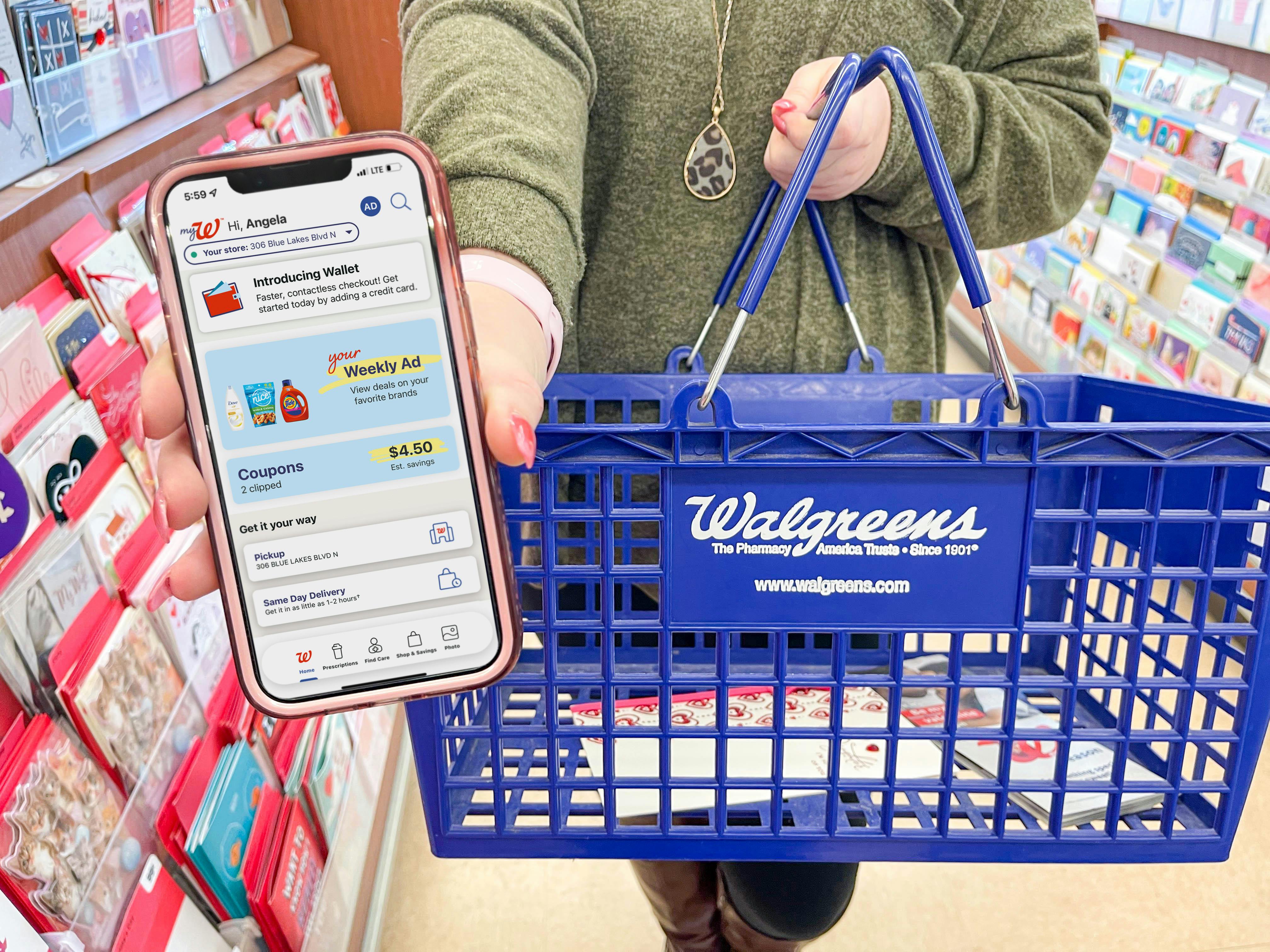 woman holding cellphone with walgreens app while holding walgreens basket