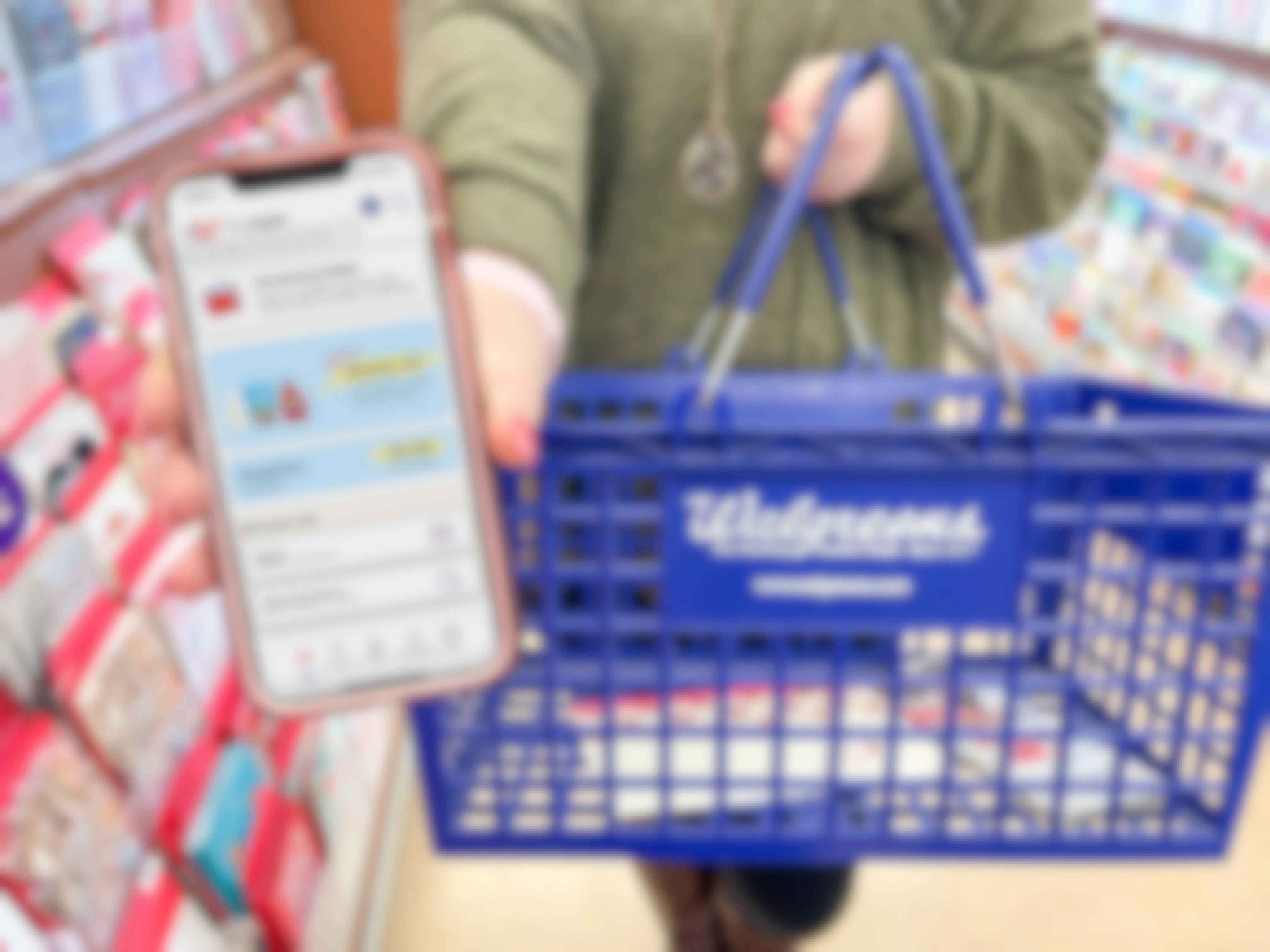 woman holding cellphone with walgreens app while holding walgreens basket
