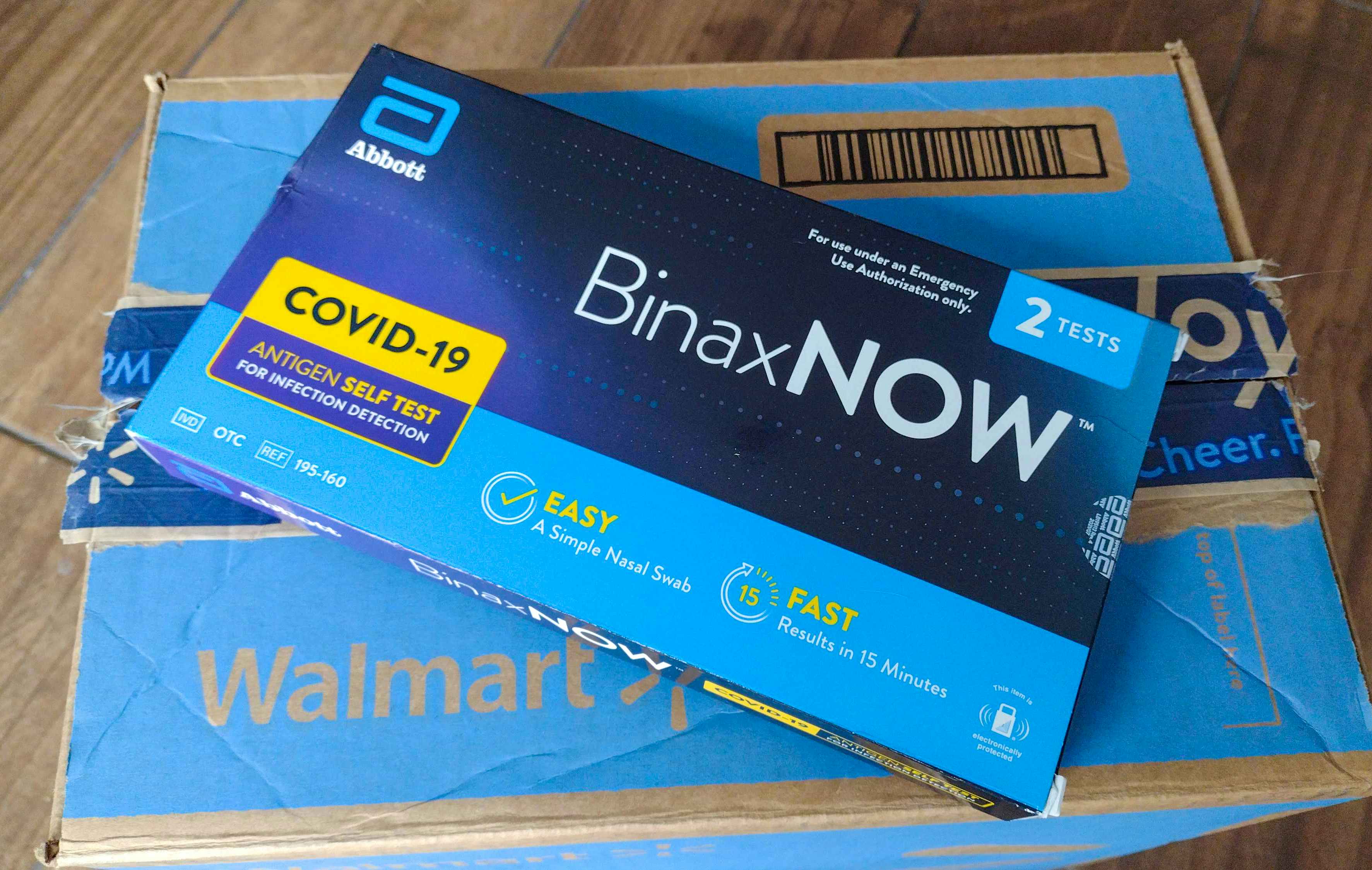 An at-home COVID-19 test kit sitting on top of a Walmart delivery box.
