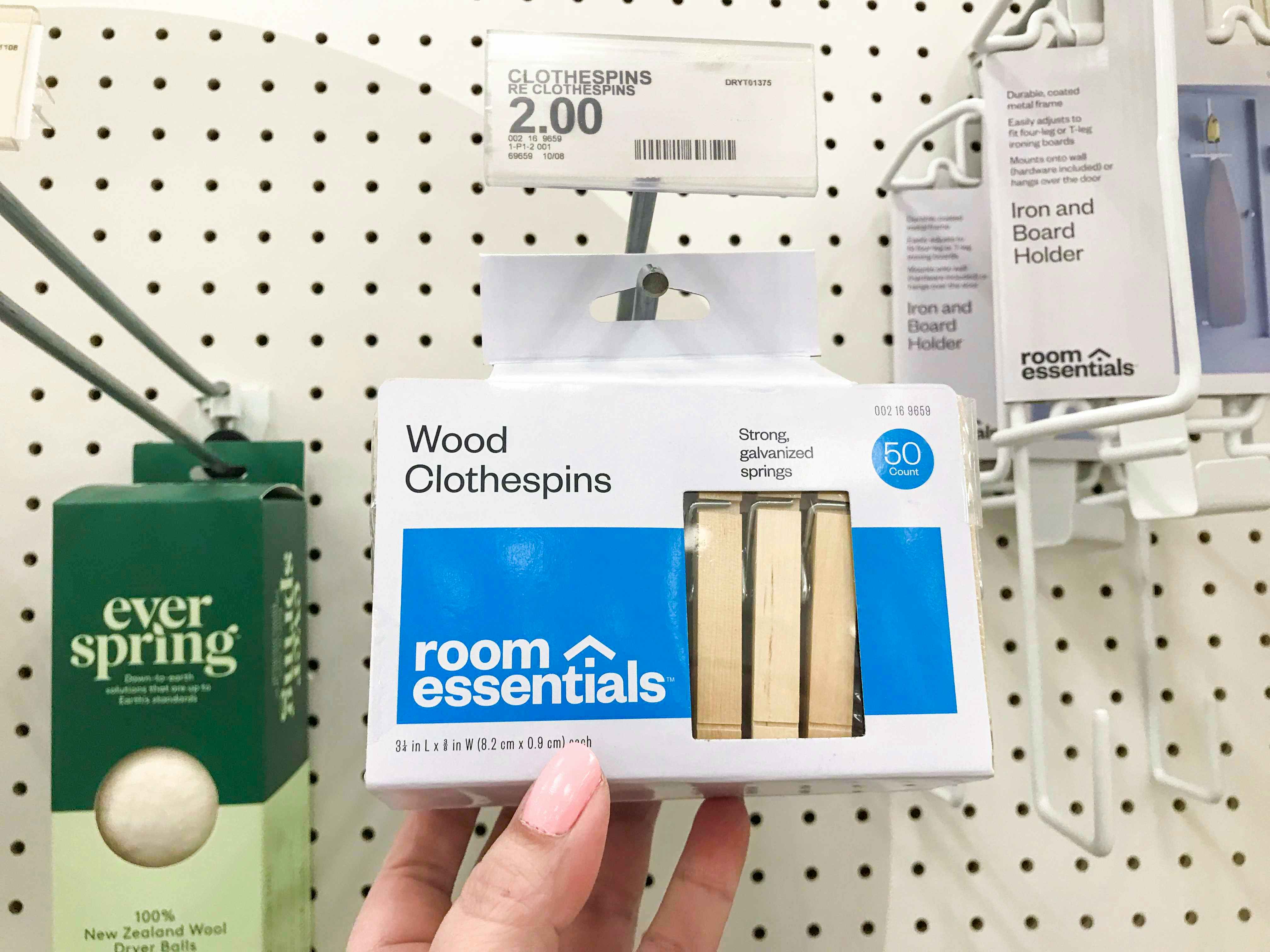 hand grabbing pack of wooden clothespins off Target hanging shelf