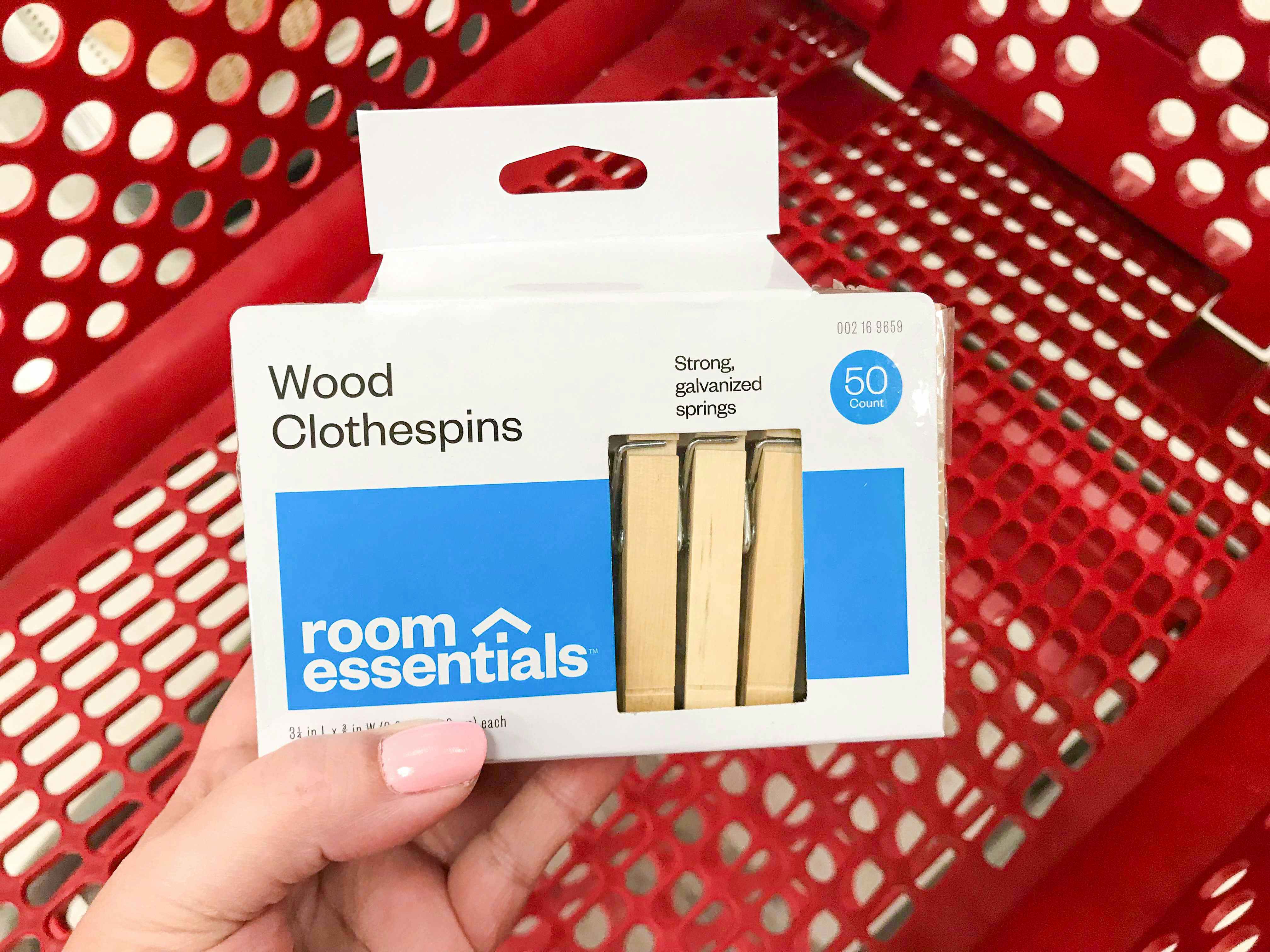 pack of wooden clothespins being held over a shopping cart at Target
