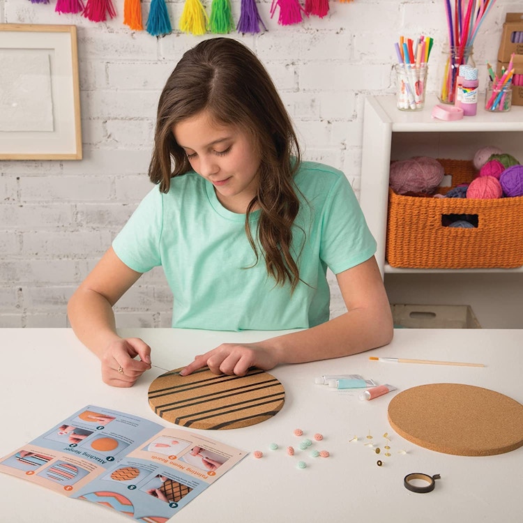 A girl doing crafts at a table with cork board circles