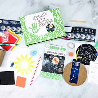 Green kid Crafts subscription box on a table with its contents focusing on space displayed