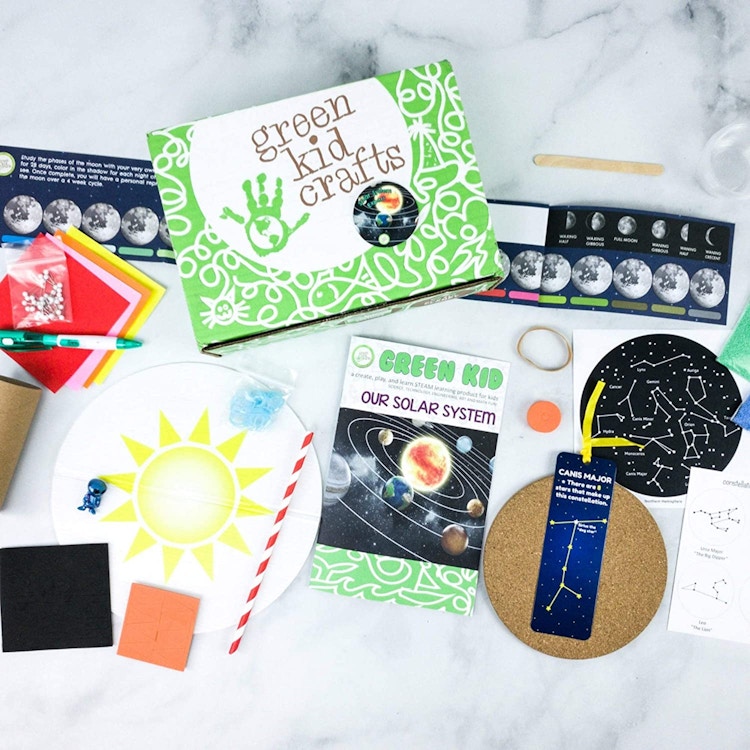 Green kid Crafts subscription box on a table with its contents focusing on space displayed