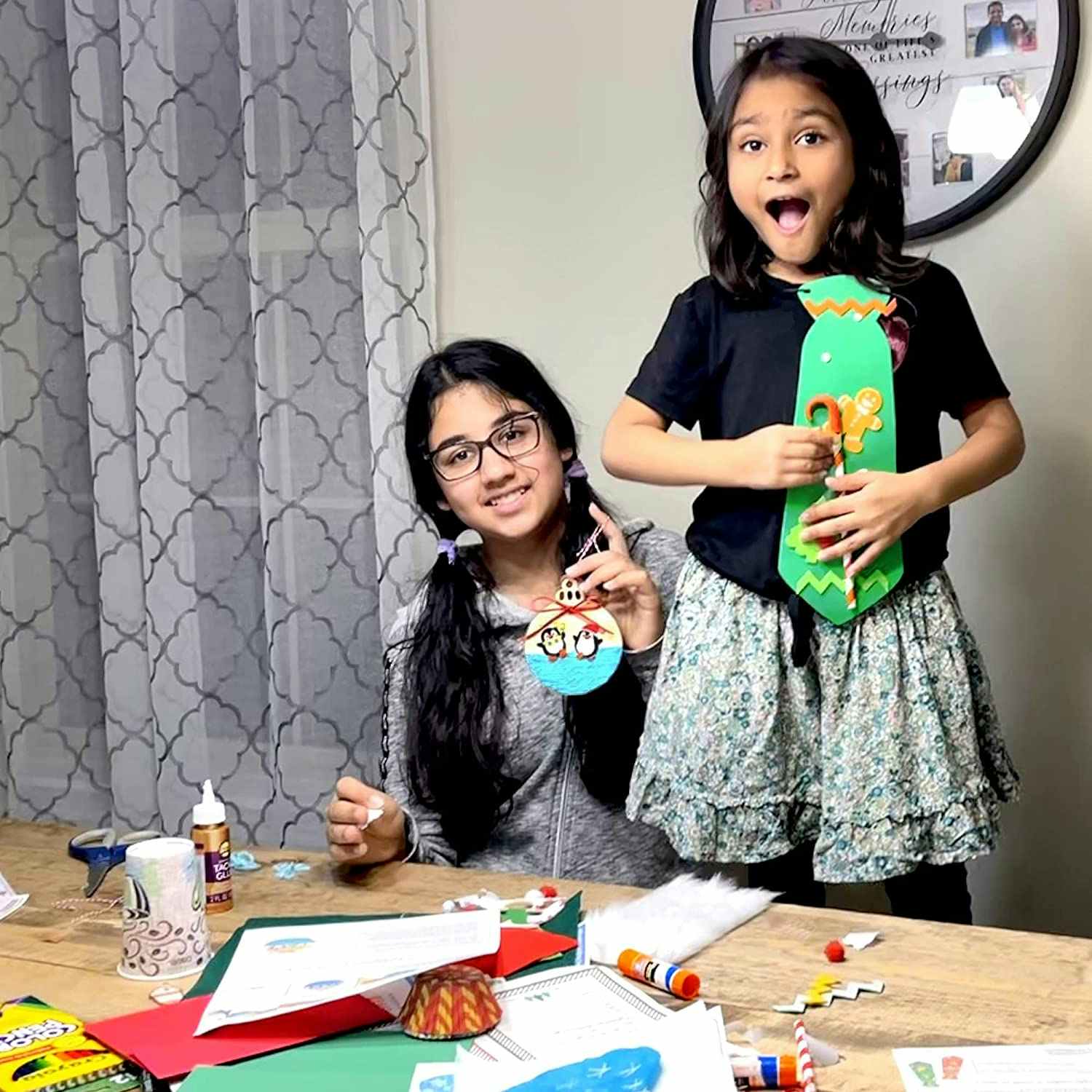 Two young girls sitting at a dining table doing crafts