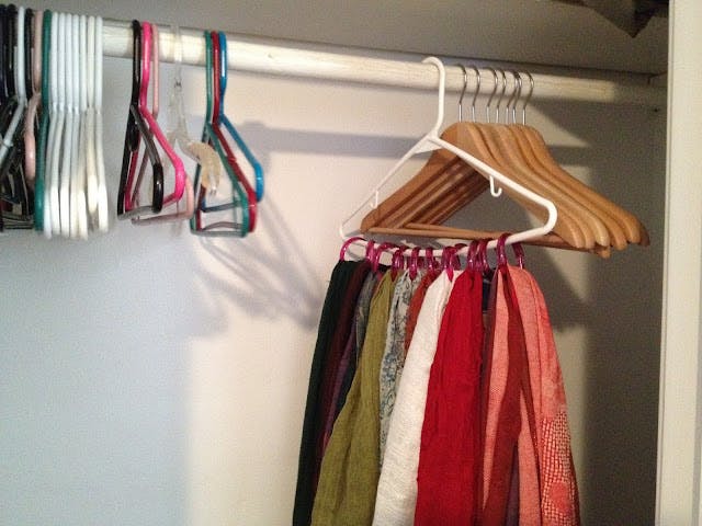 hanger in a closet being used as a scarf organizer