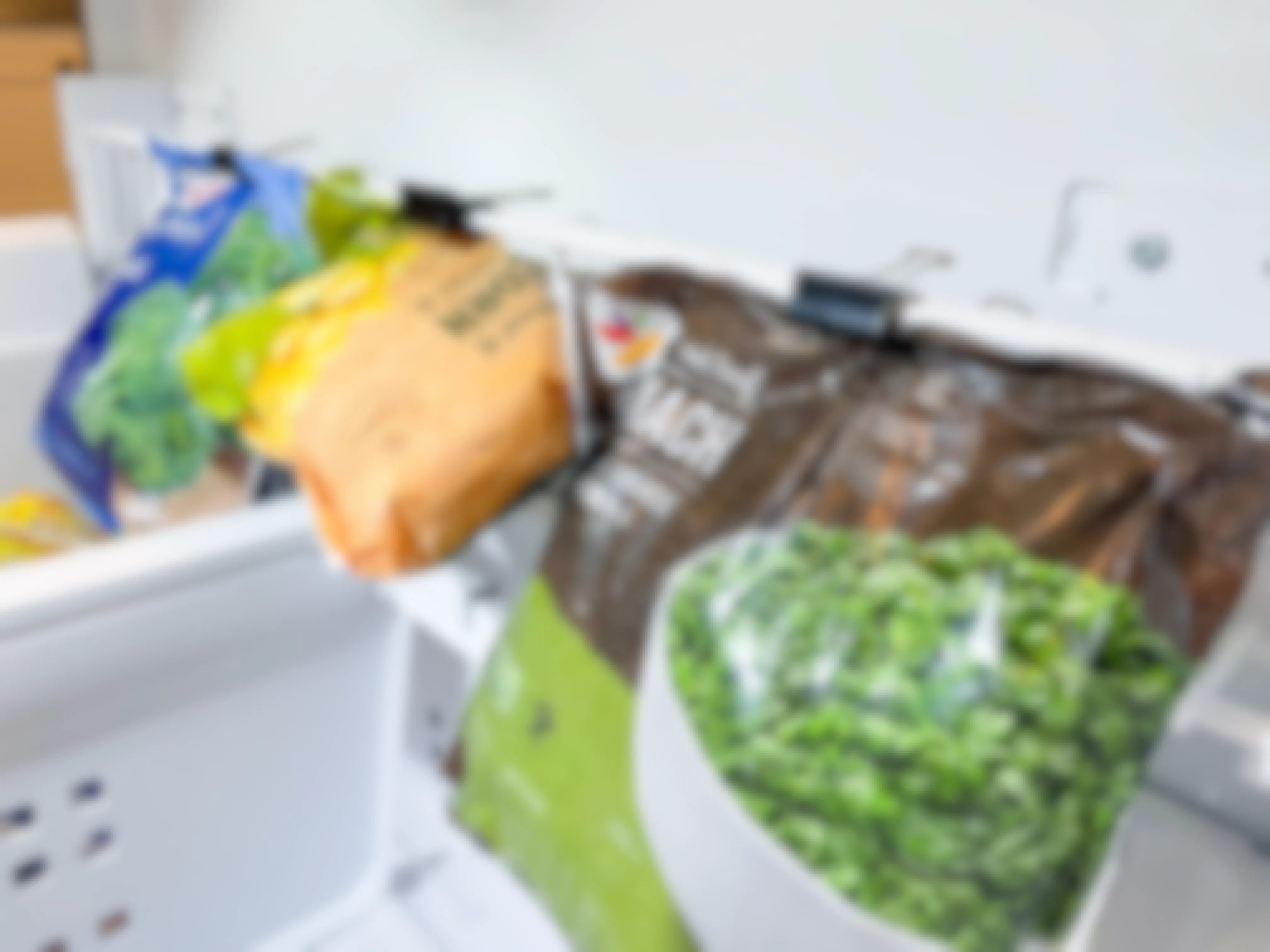 binder clip organization hack showing frozen veggies hanging from binder clips in freezer