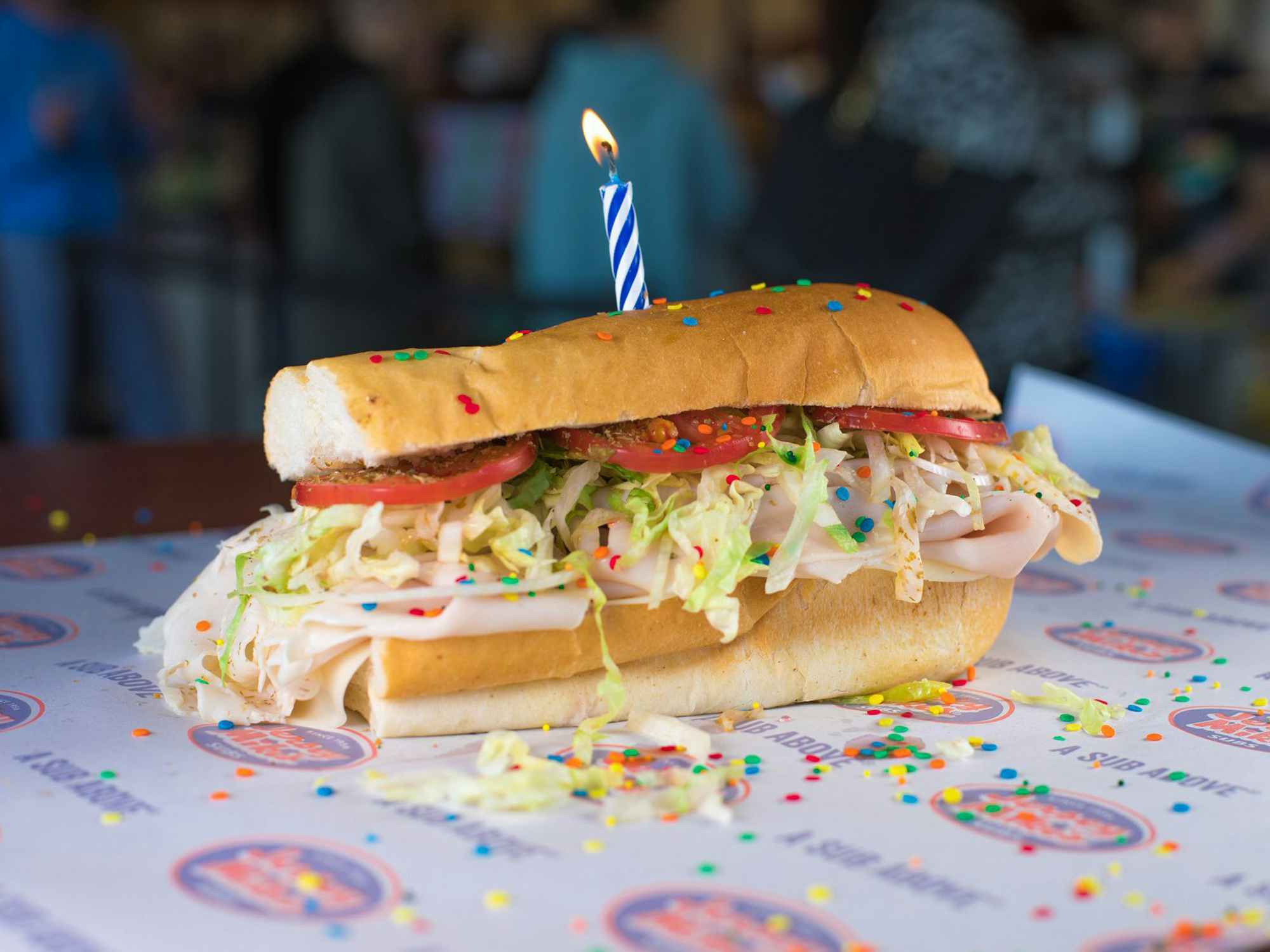 A Jersey Mike's sub with a birthday candle stuck into it