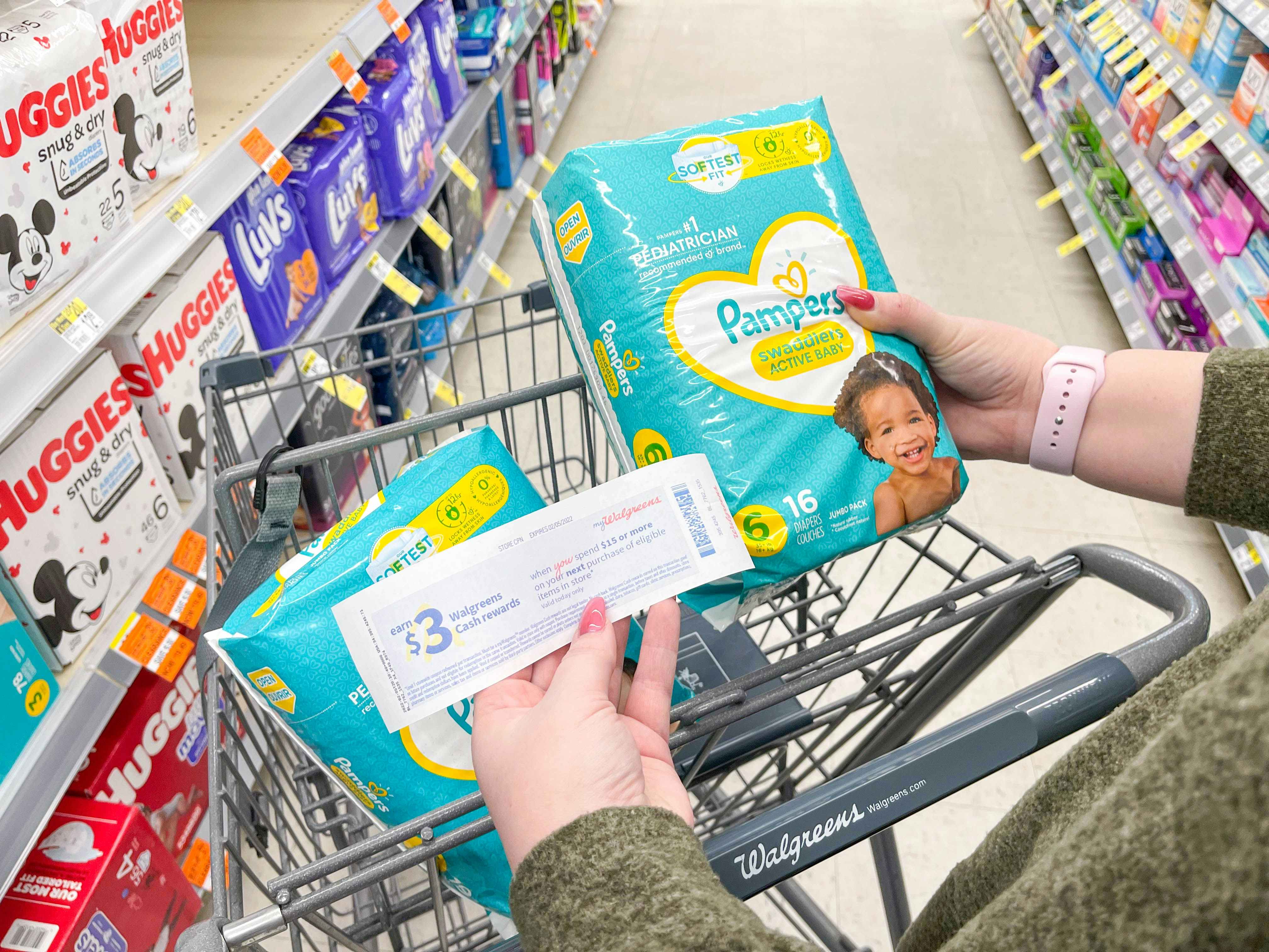 holding pampers diapers while holding walgreens cash rewards
