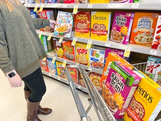 Person putting cereal in Walgreen's cart