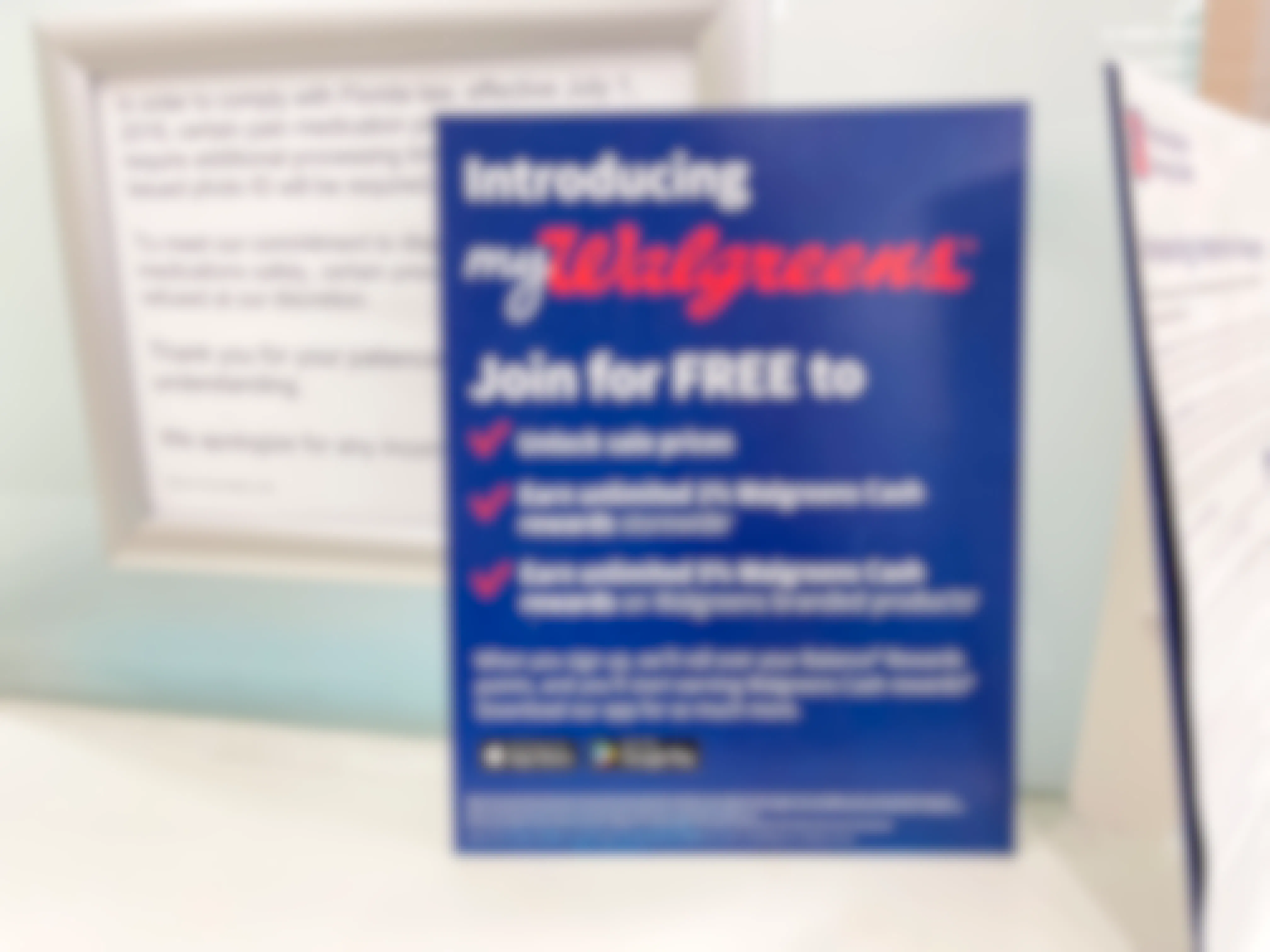 A sign for the myWalgreens rewards program on a counter in walgreens