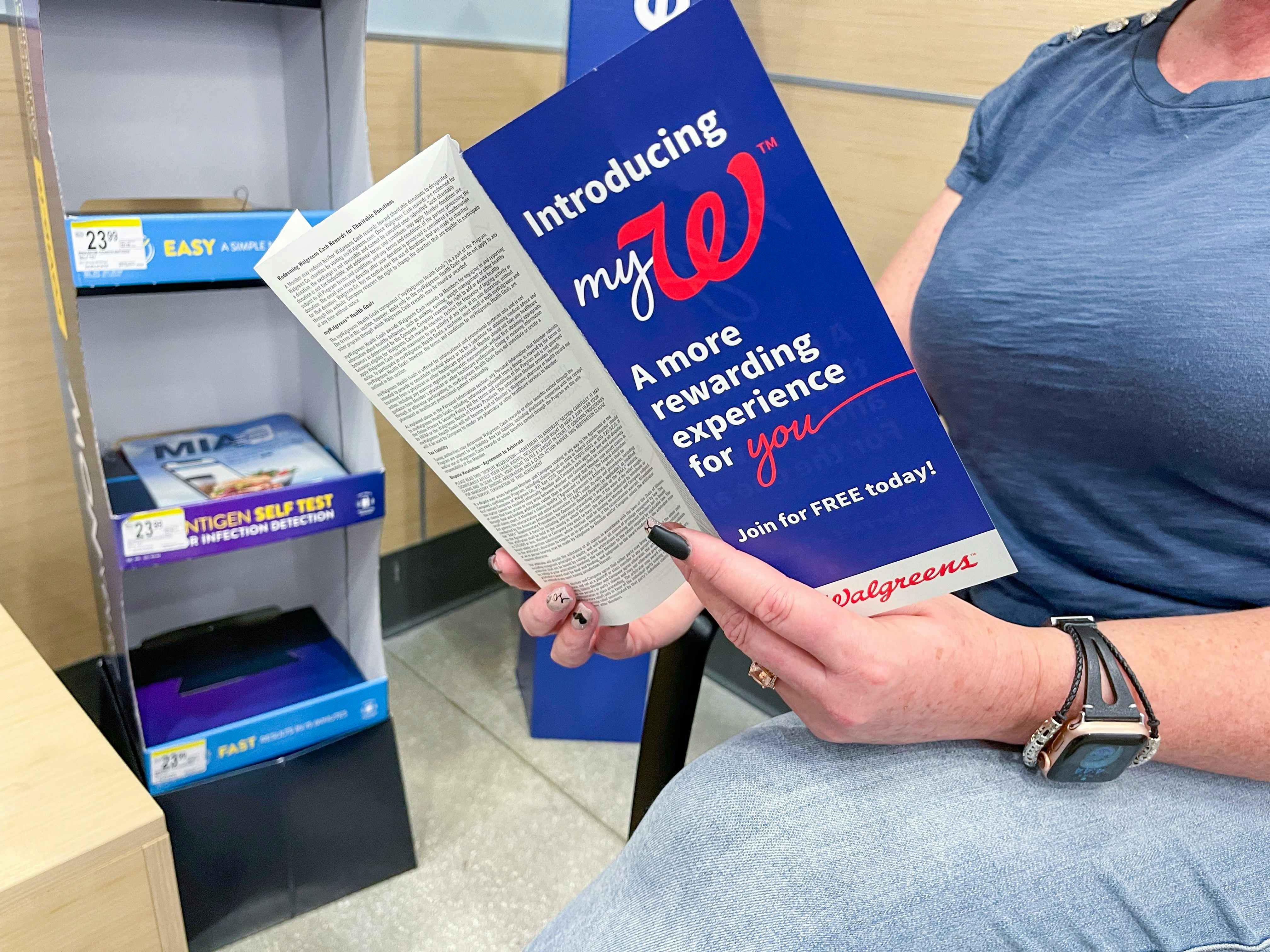 A person looking through a Walgreens MyW program book while shopping