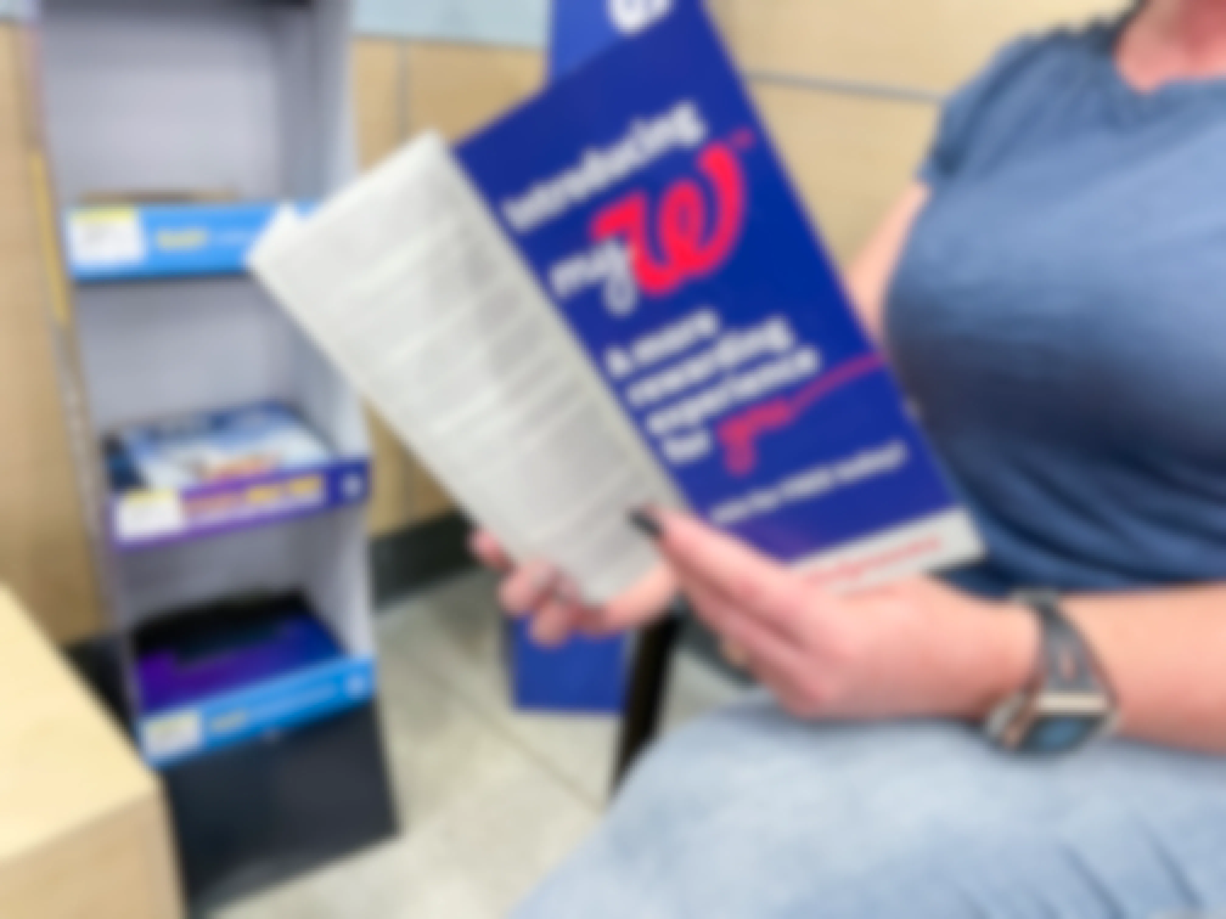 A person looking through a Walgreens MyW program book while shopping