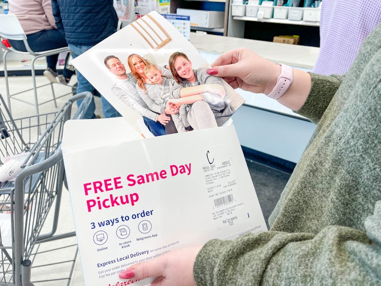 woman holding walgreens photo packet and holding a 8x10 print