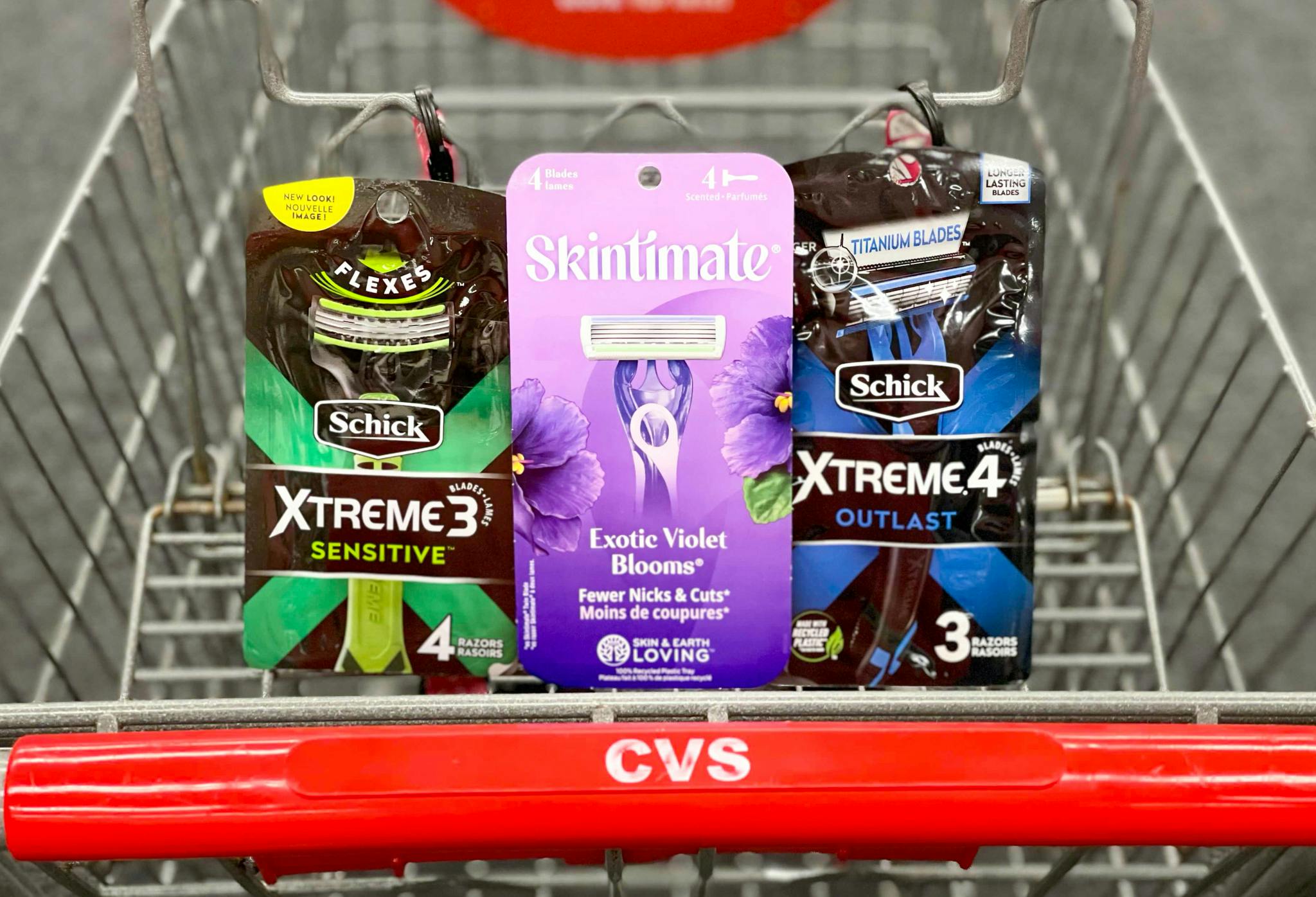 Packages of Schick Xtreme 3, Schick Xtreme 4, and Skintimate disposable razors sitting in the basket of a CVS cart.