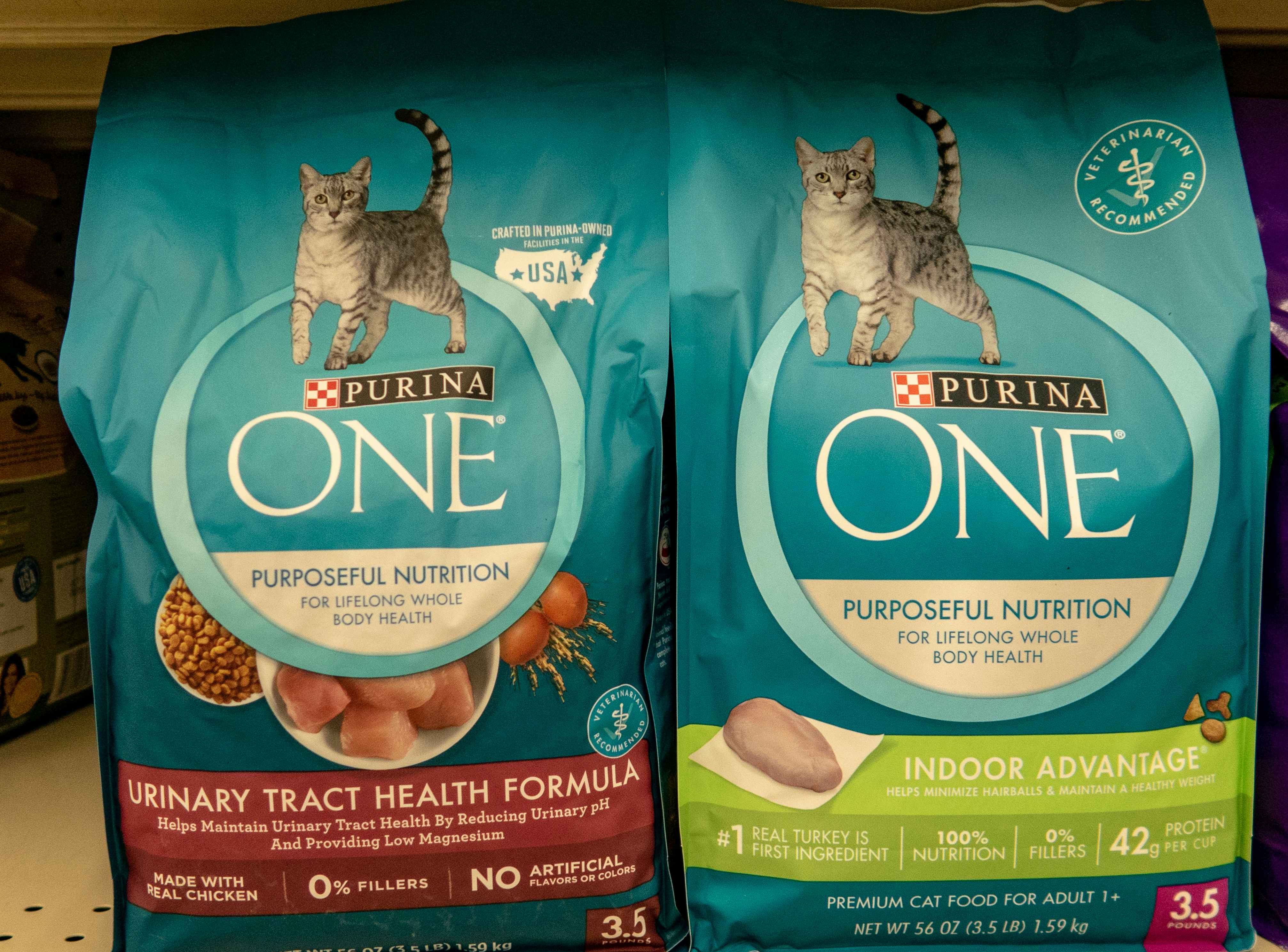 two blue bags of purina one cat chow on the shelf at the grocery store