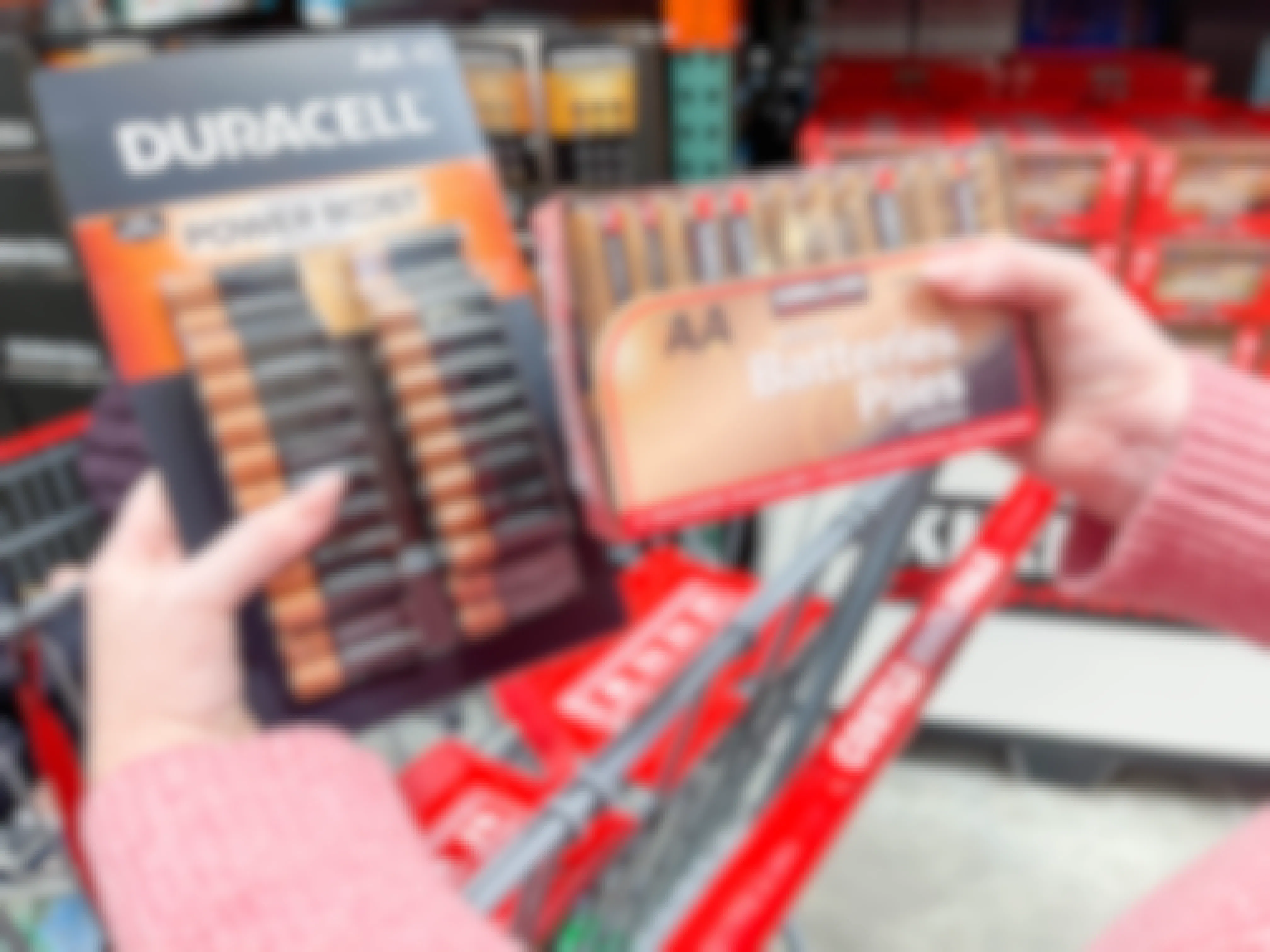 a person holding two makes of batteries at costco