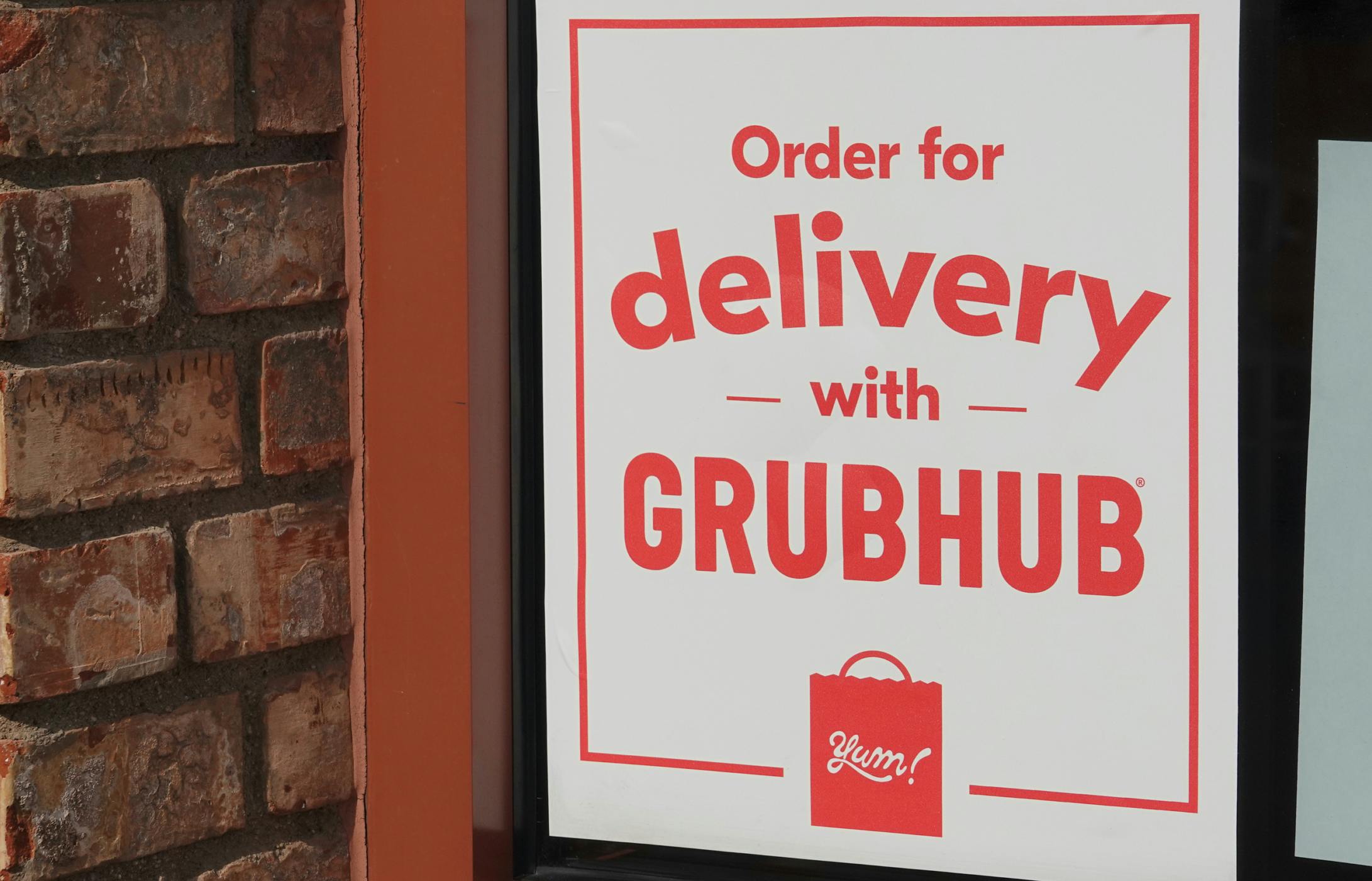 A Grubhub delivery sign on a restaurant window.