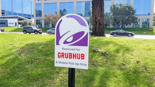 - A Taco Bell sign positioned at a parking space. The sign has the Taco Bell logo and reads