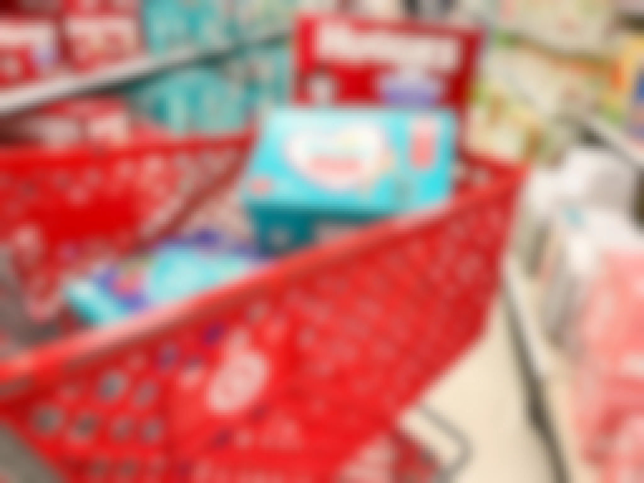 A Target cart with Huggies and Pampers diapers in it.