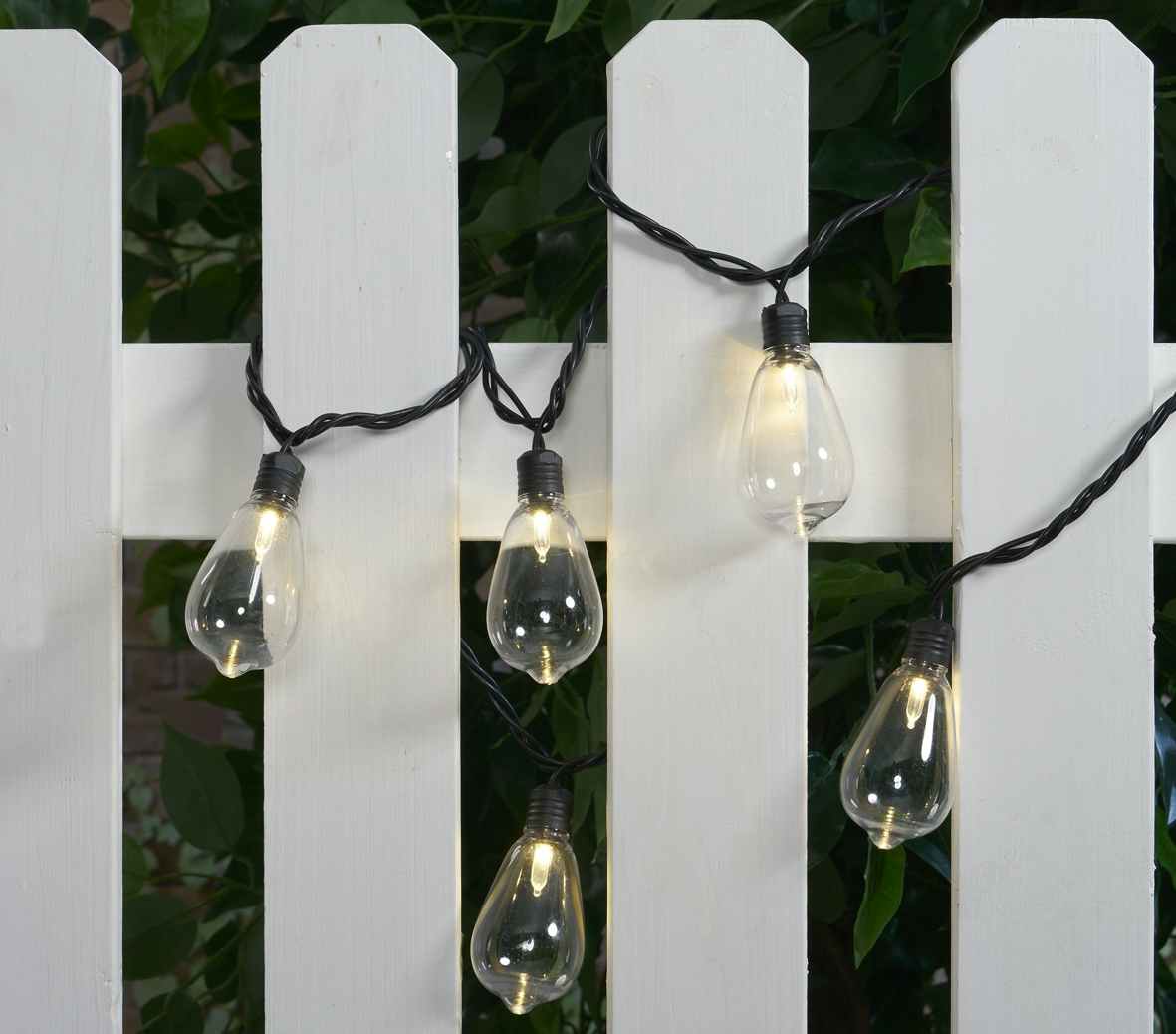 screenshot of Walmart's mainstays outdoor string lights; lights are shown wrapped around white fencing