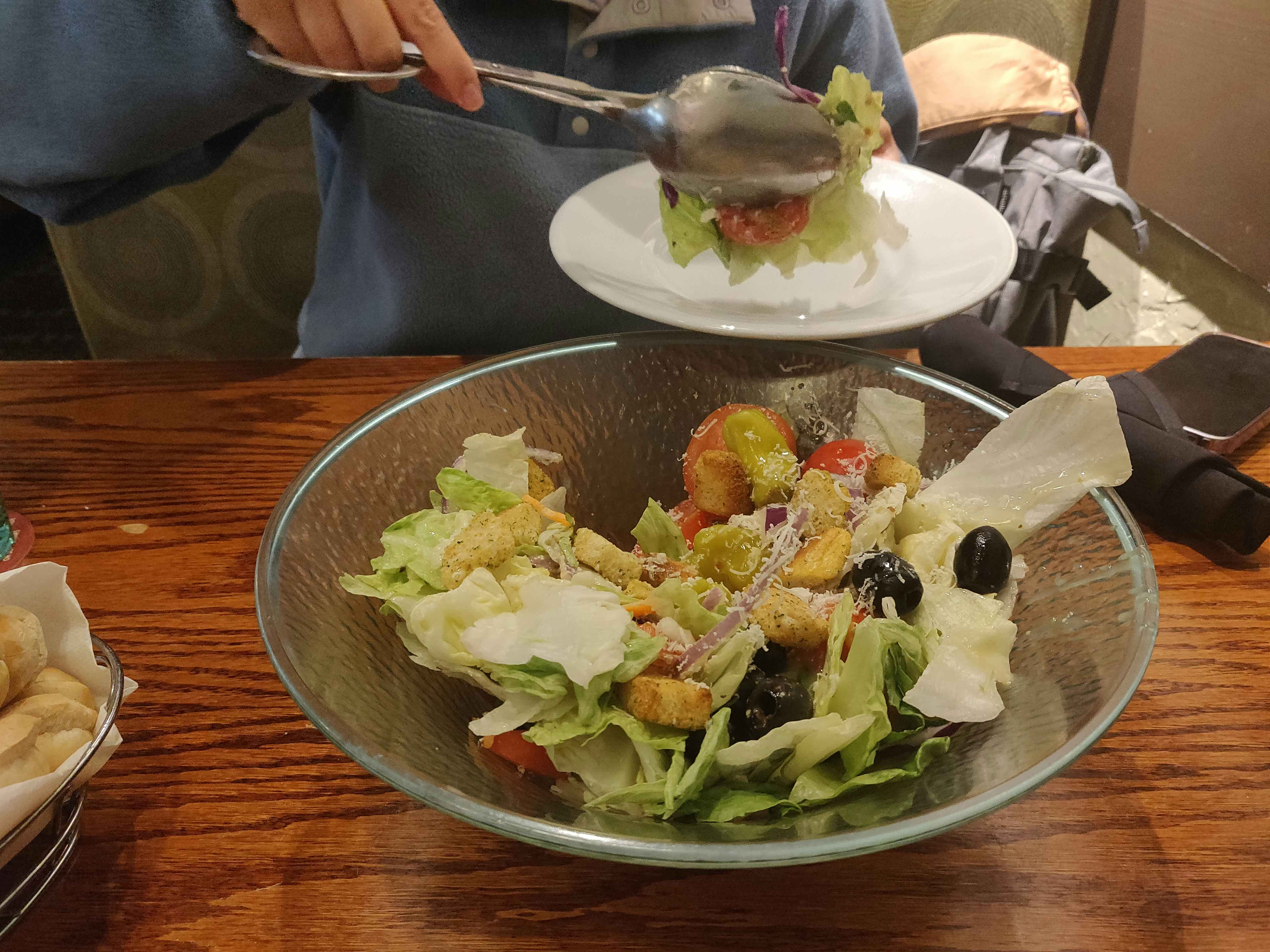 woman putting salad on her plate at olive garden