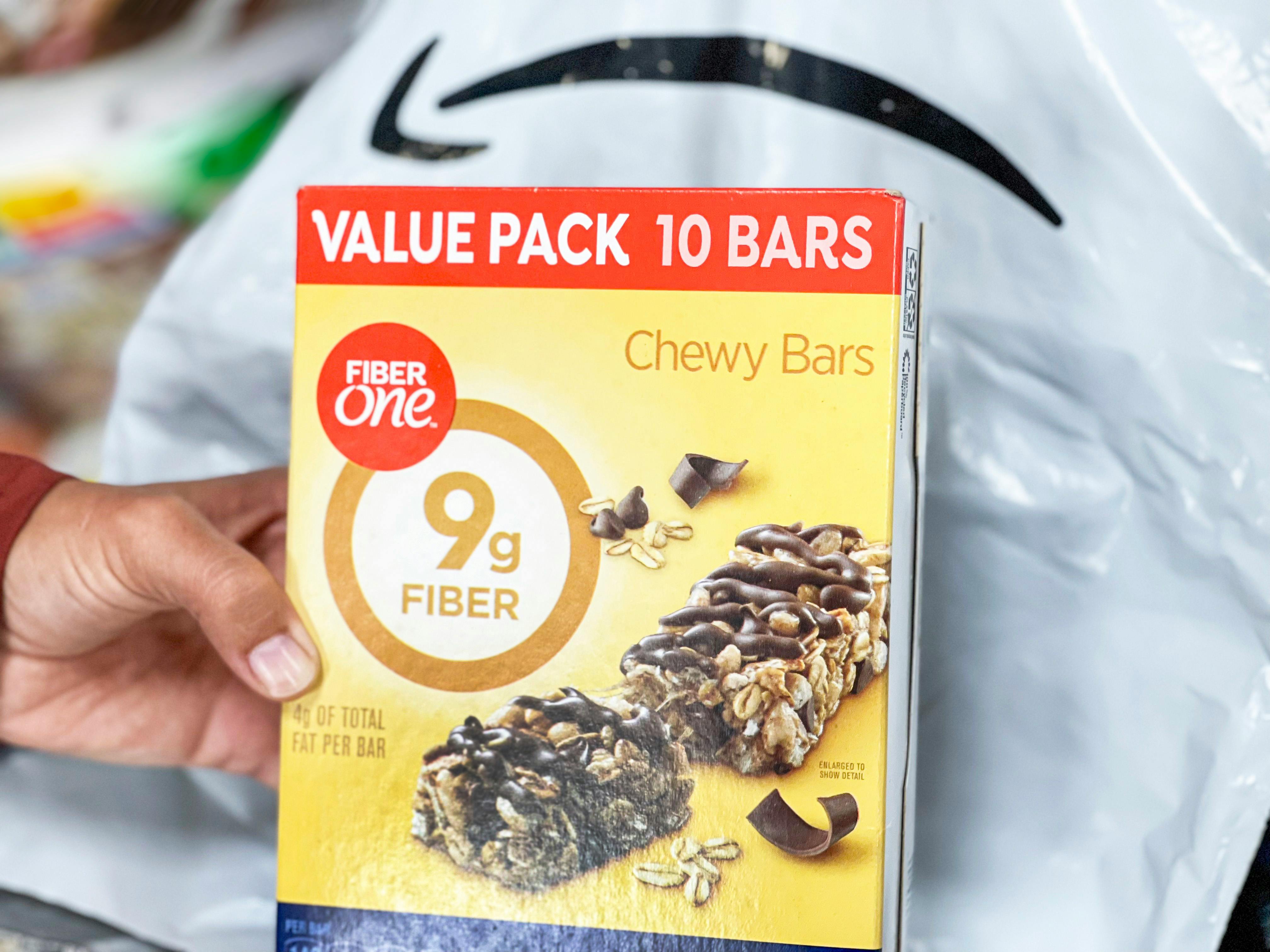 a person holding a box of fiber one bars 