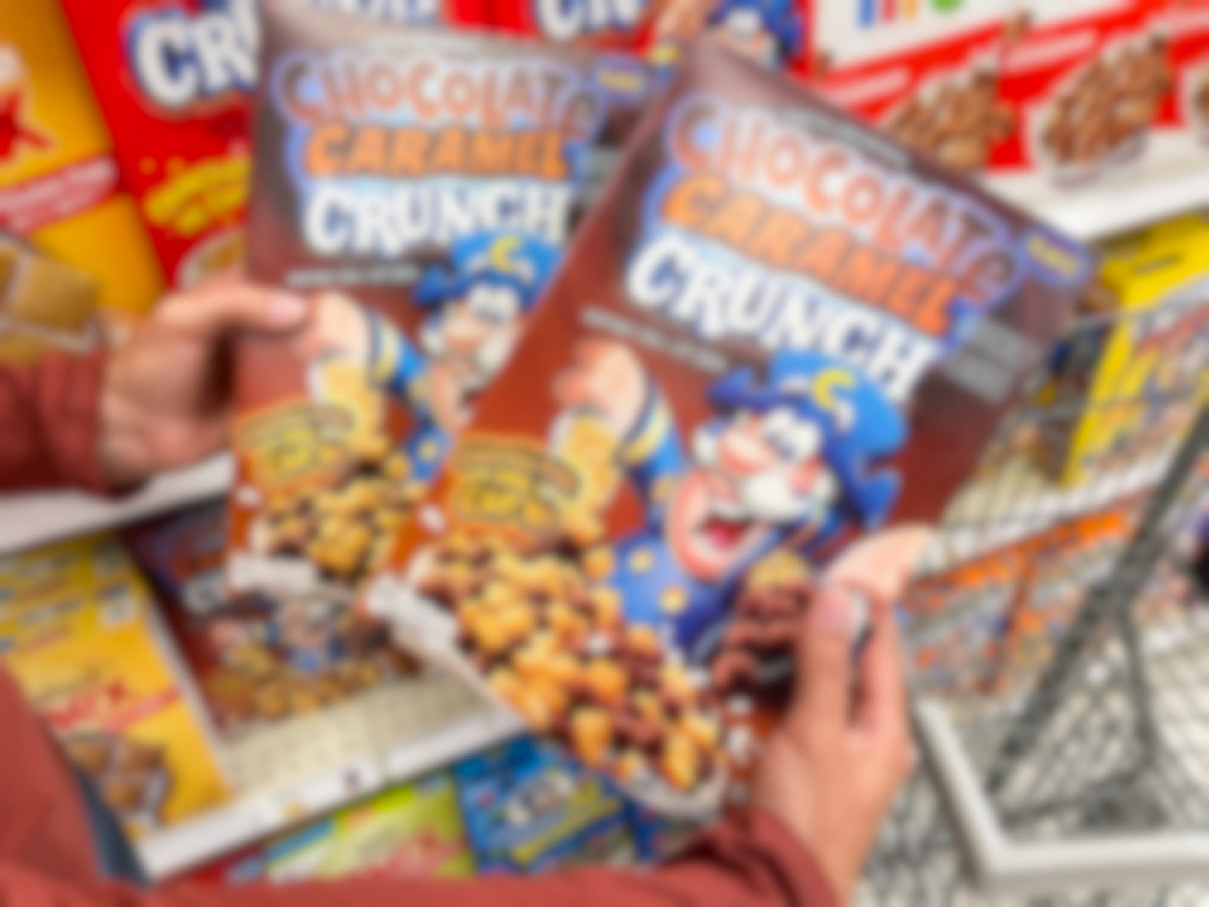a person holding two boxes of capn crunch in store