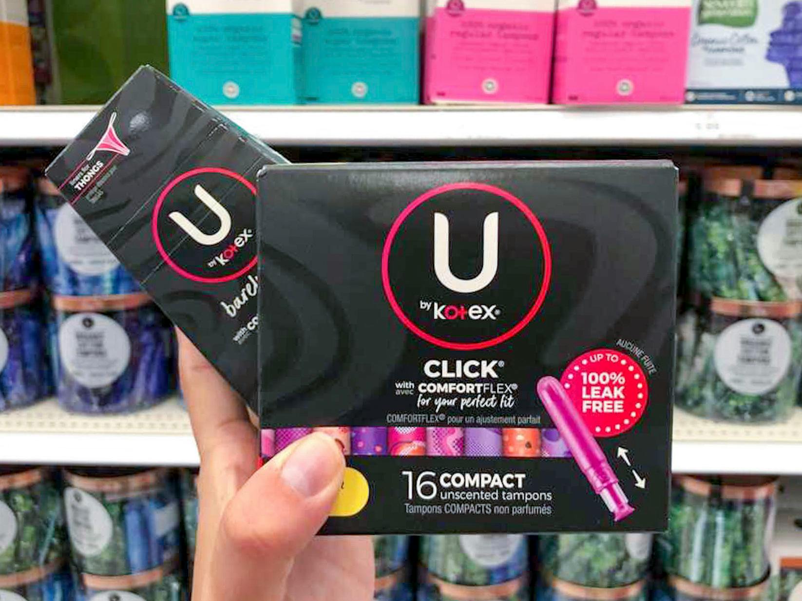 U by Kotex tampons and pads held in a woman's hand in front of a shelf at Target